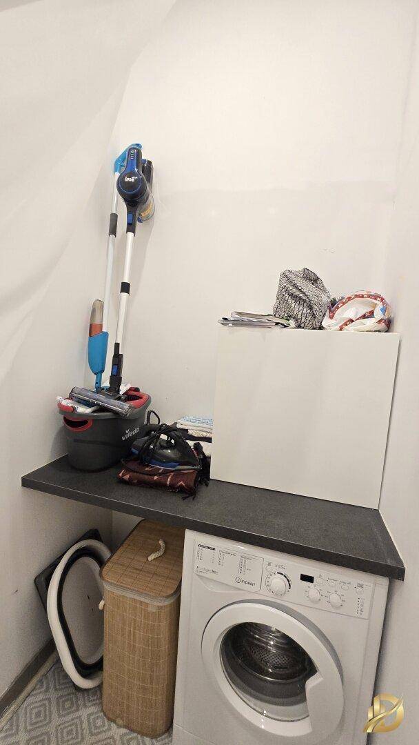 Praktischer Hauswirtschaftsraum mit Waschmaschine, Ablagefläche und Reinigungsutensilien.