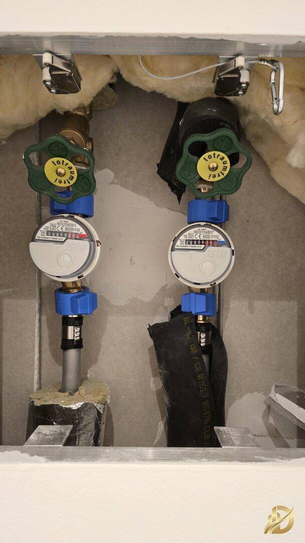 Technikraum mit Wasserzählern und Rohrleitungen, die die Versorgung des Gebäudes regeln.