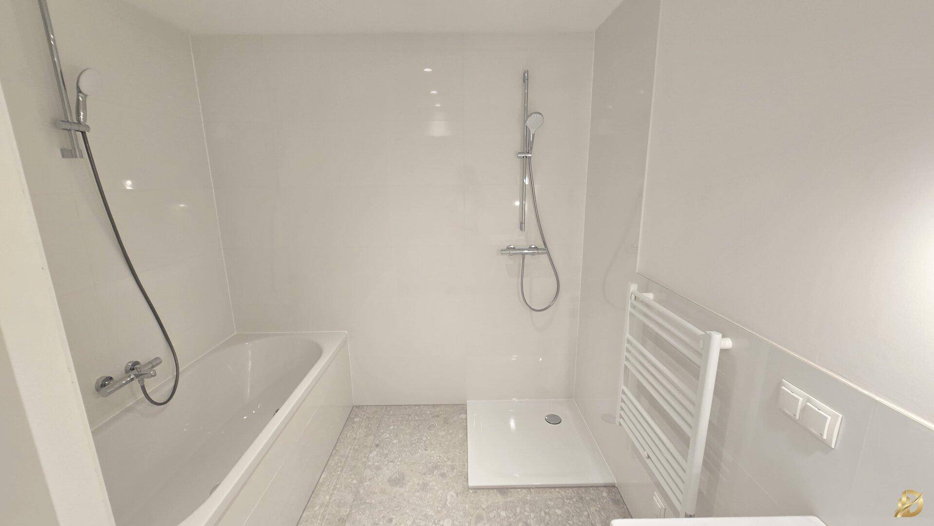 Zeitgemäßes Badezimmer mit Badewanne, Dusche und praktischem Handtuchheizkörper.