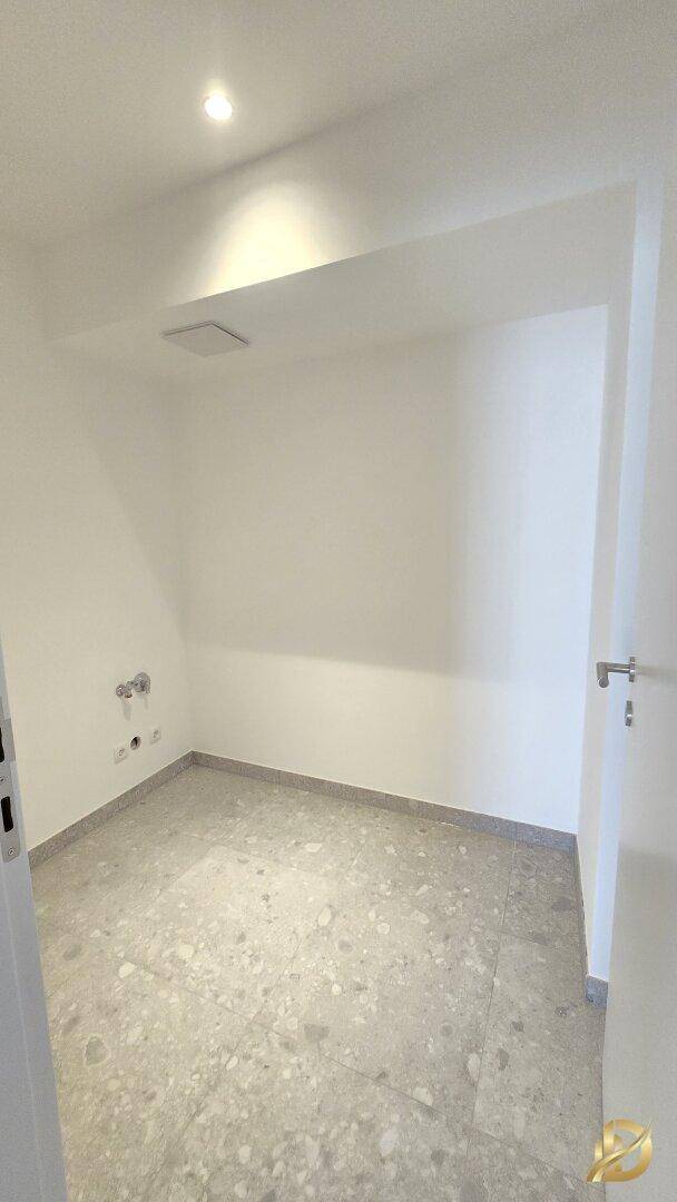 Praktischer Hauswirtschaftsraum mit Fliesenboden und Anschlüssen für Waschmaschine oder Trockner.