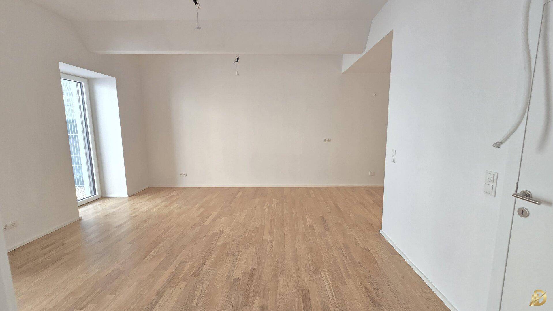 Helles Zimmer mit Holzboden und einem großen Fenster, bietet viel Tageslicht.