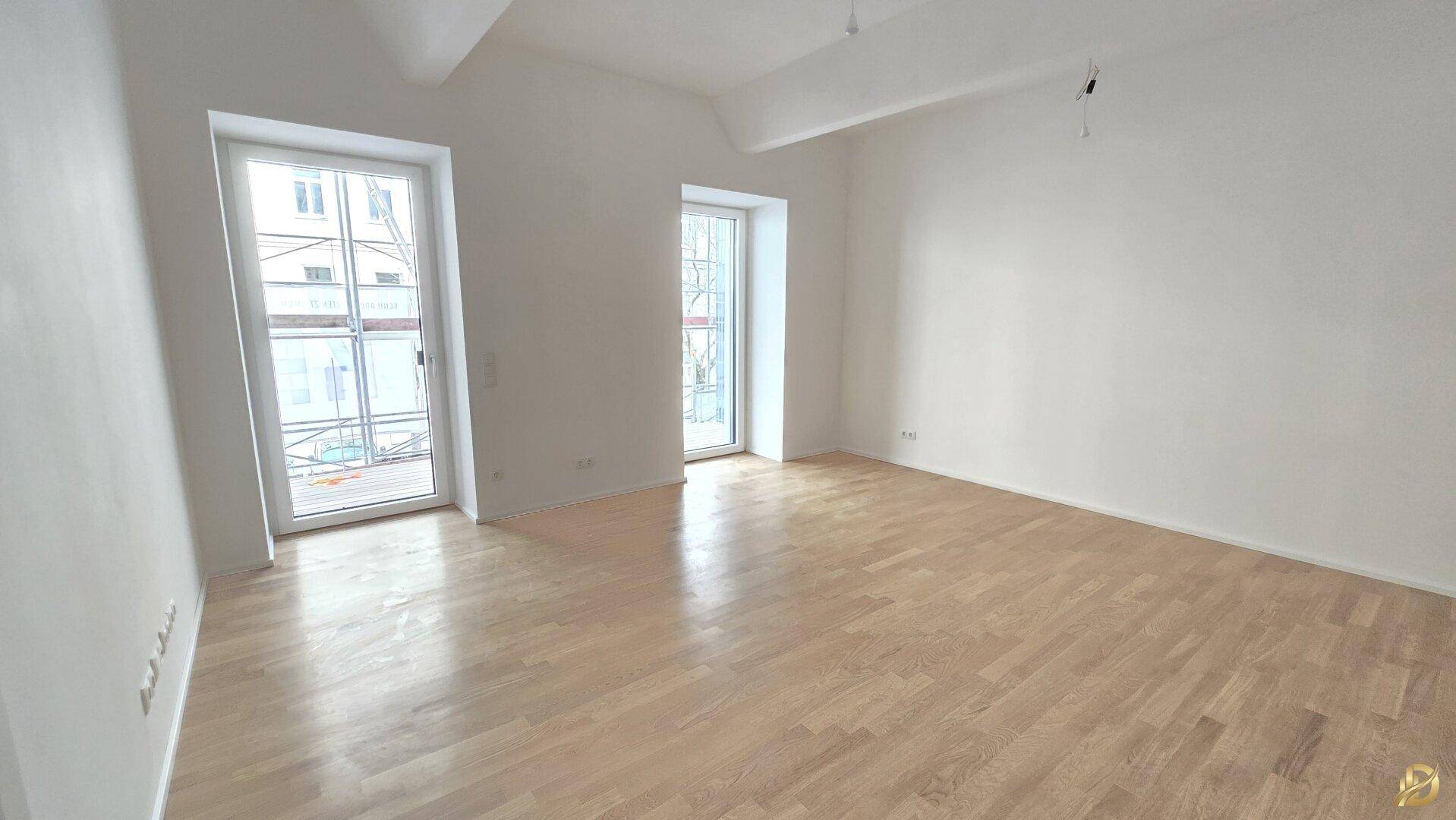 Helles Zimmer mit neuem Parkettboden und zwei Fenstern, bietet viel Tageslicht.