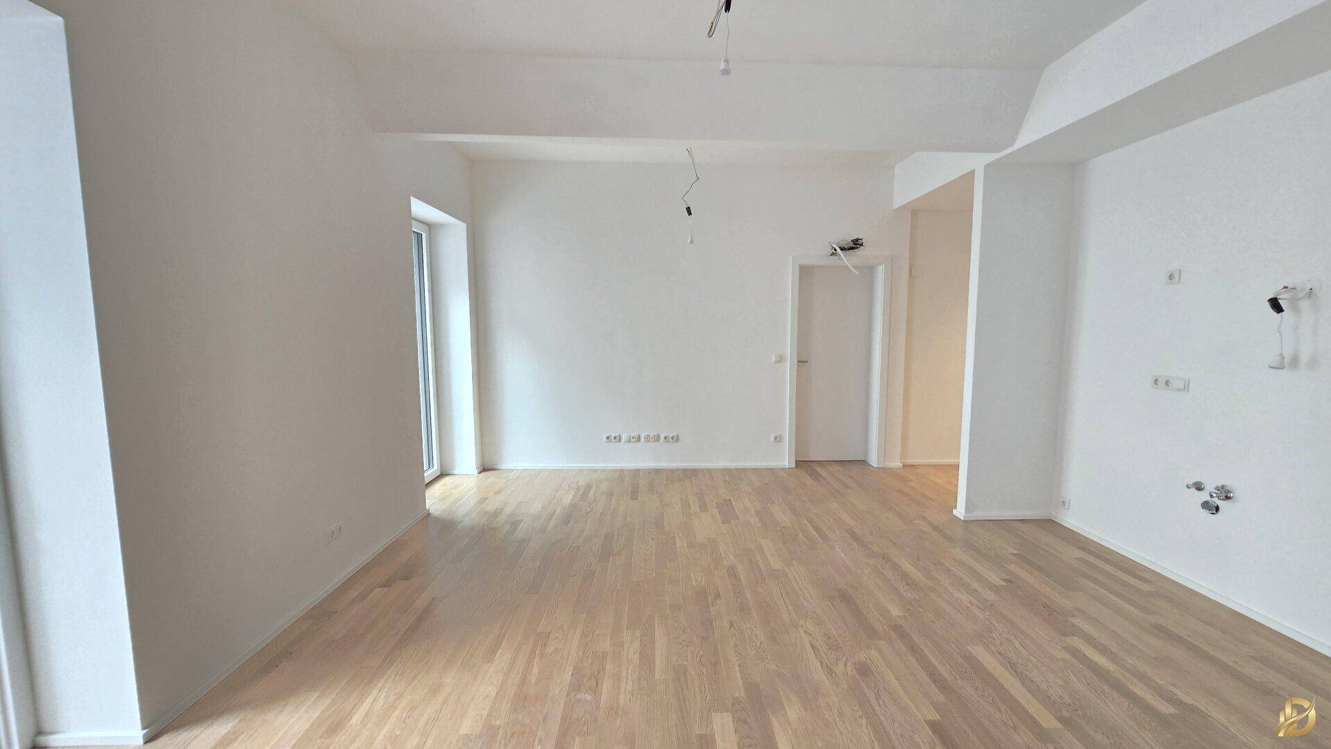 Geräumiges, helles Zimmer mit Parkettboden und Zugang zu einem französischen Balkon.