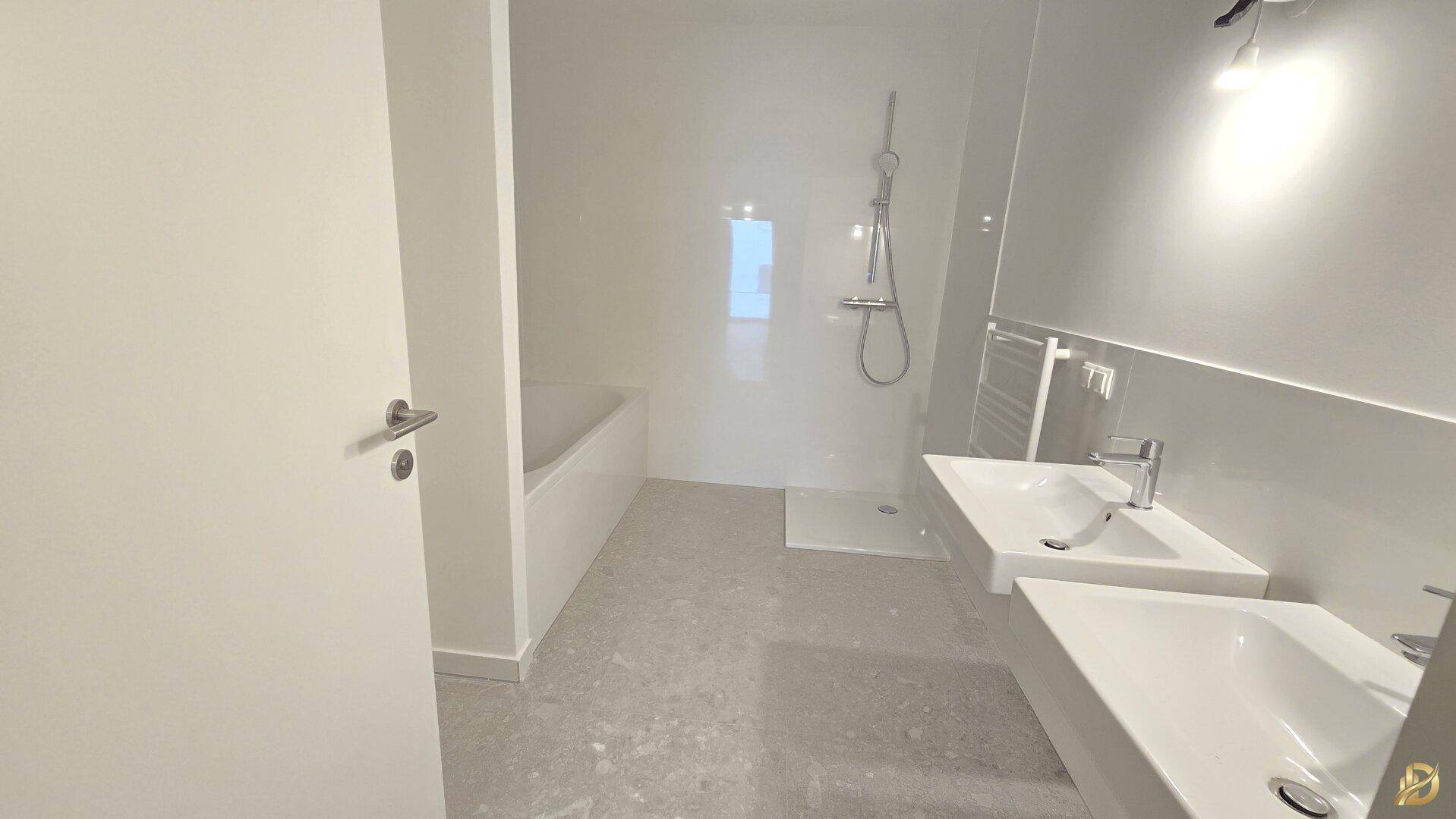 Modernes Badezimmer mit Doppelwaschbecken, Badewanne und Dusche.