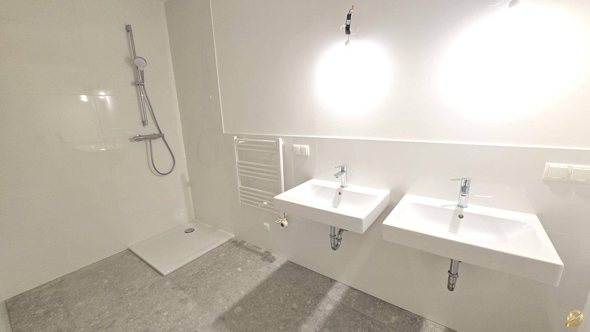 Modernes Badezimmer mit Doppelwaschbecken, Dusche und Handtuchheizkörper.