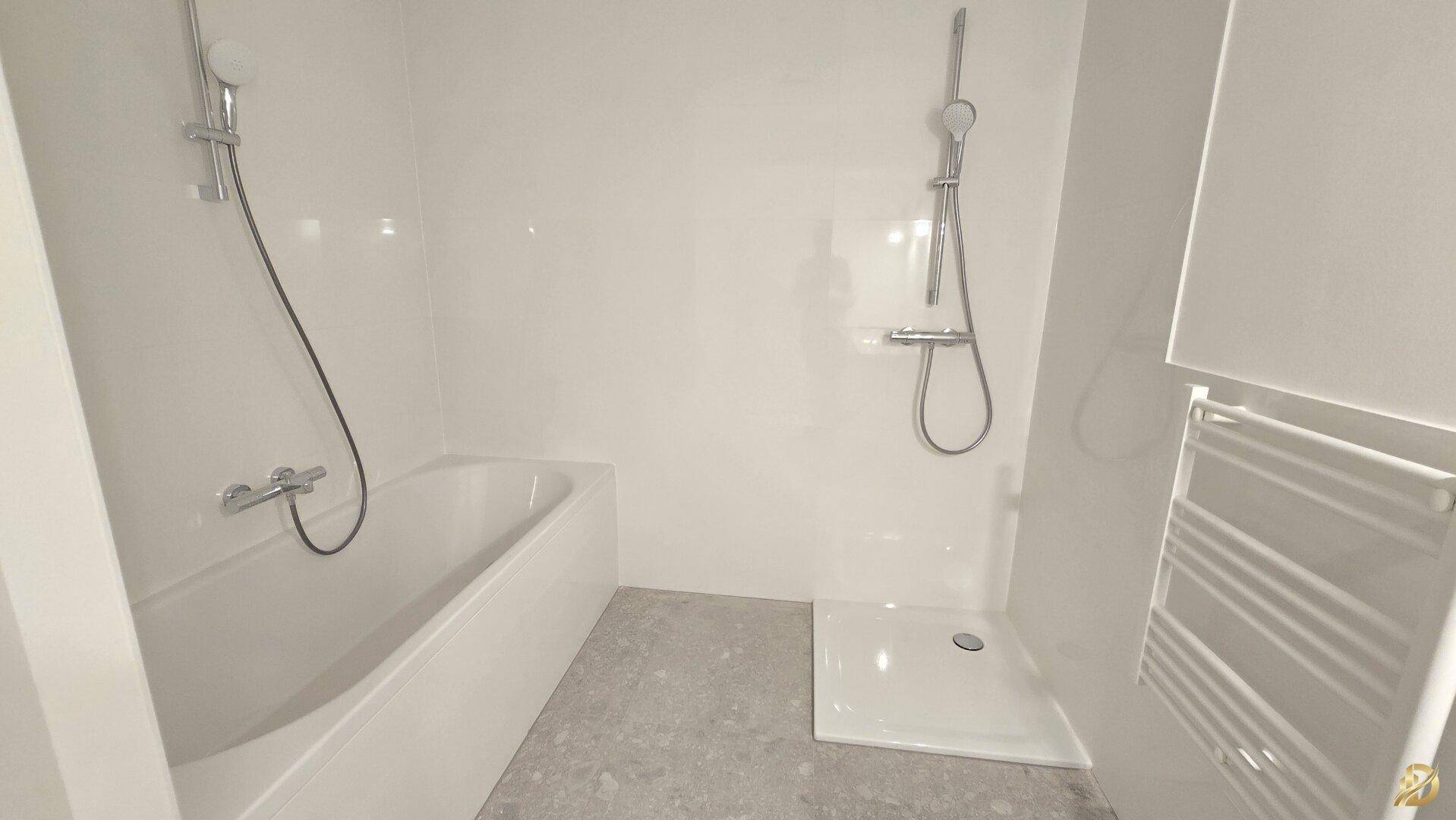 Modernes Badezimmer mit Badewanne, Dusche und Handtuchheizkörper.