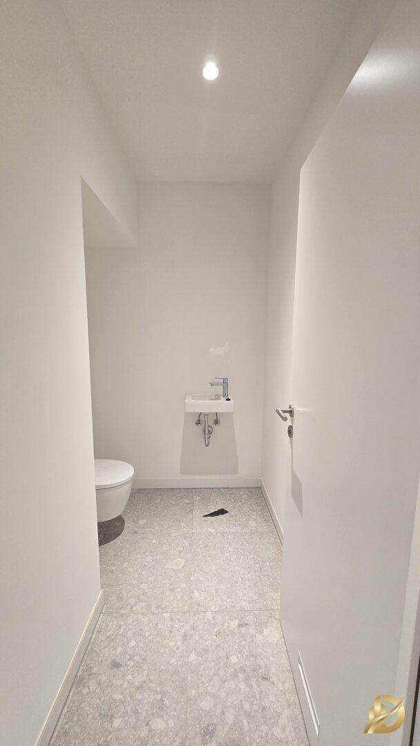Modernes Gäste-WC mit Waschbecken und Wand-WC.