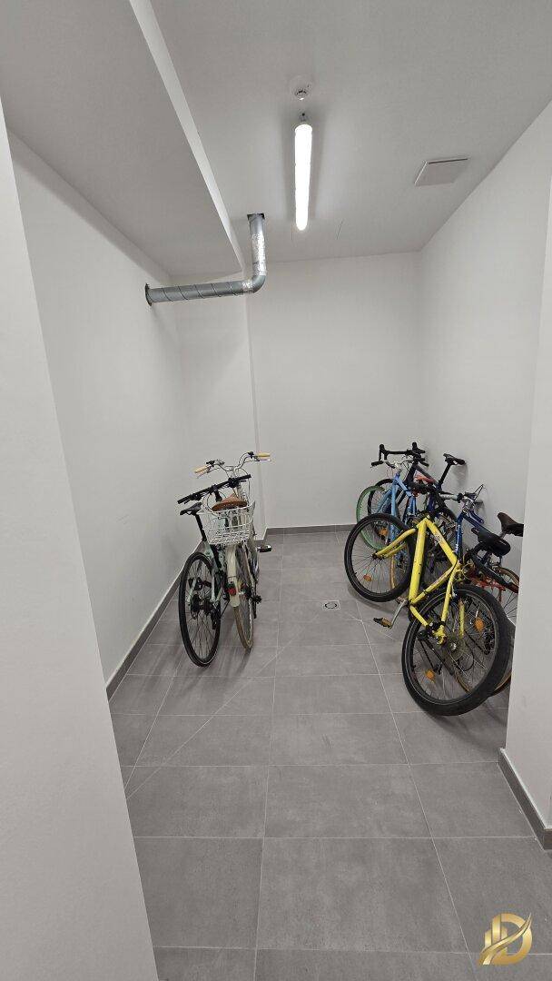 Fahrradraum mit mehreren Fahrrädern und Fliesenboden.