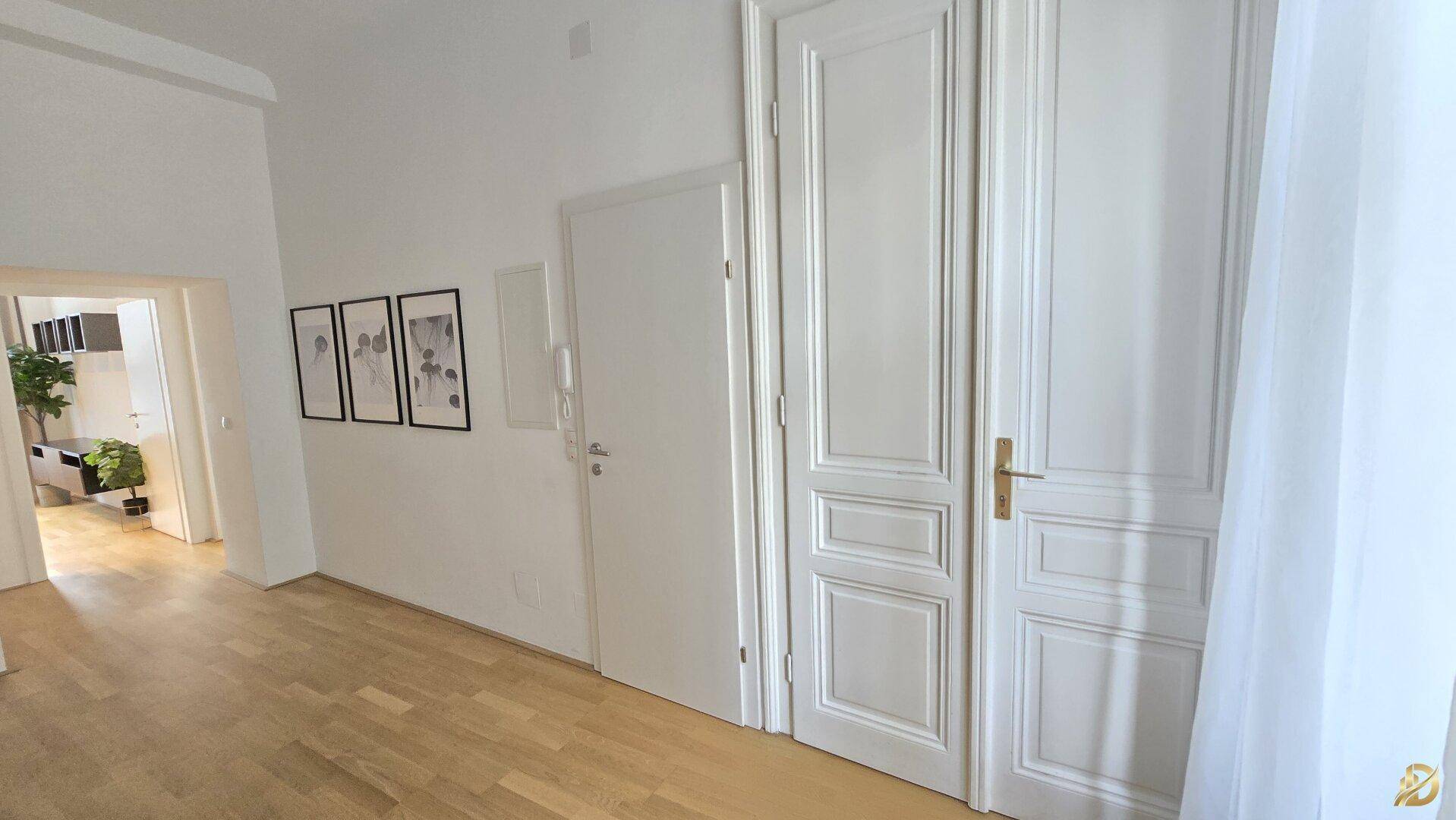 Heller Flur mit Holzboden und eleganten weißen Türen, die zu den Wohnbereichen führen.
