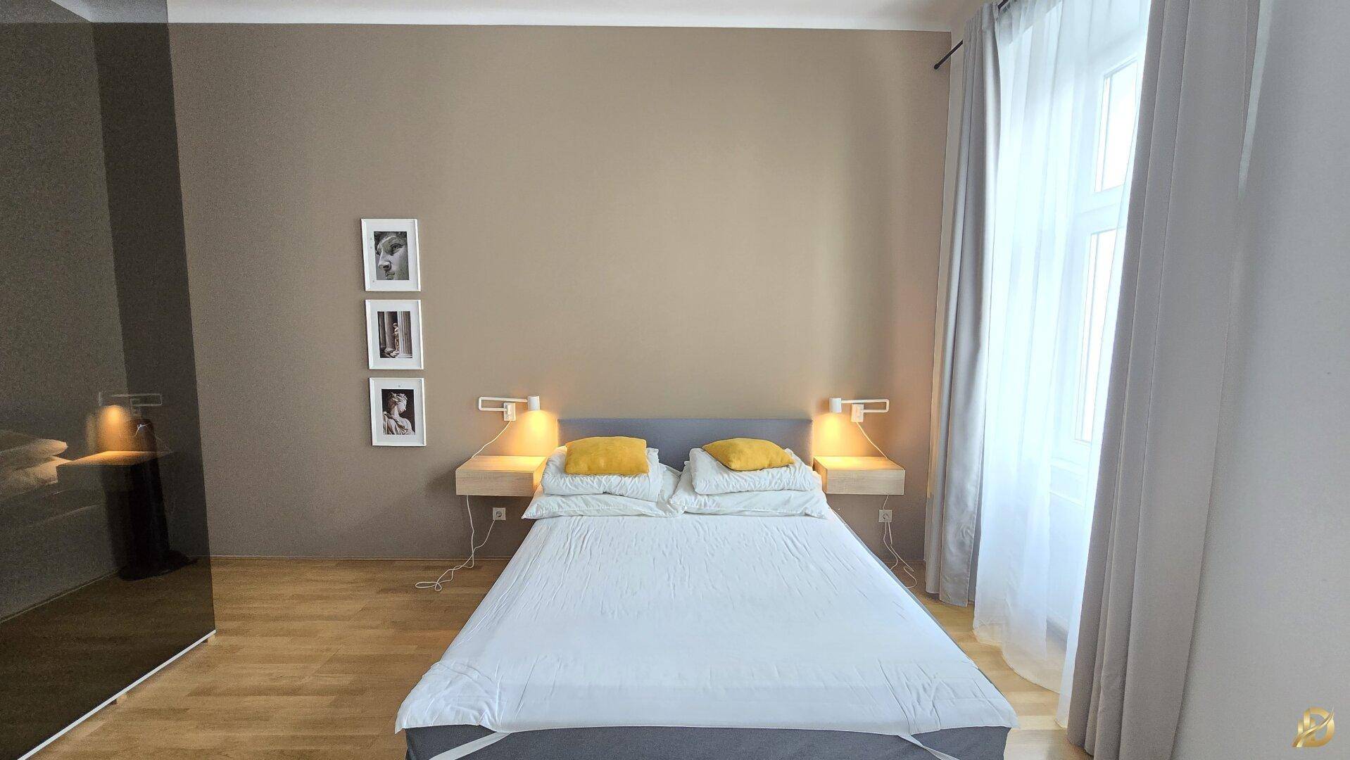 Gemütliches Schlafzimmer mit Doppelbett, schwebenden Nachttischen und warmen Wandfarben.