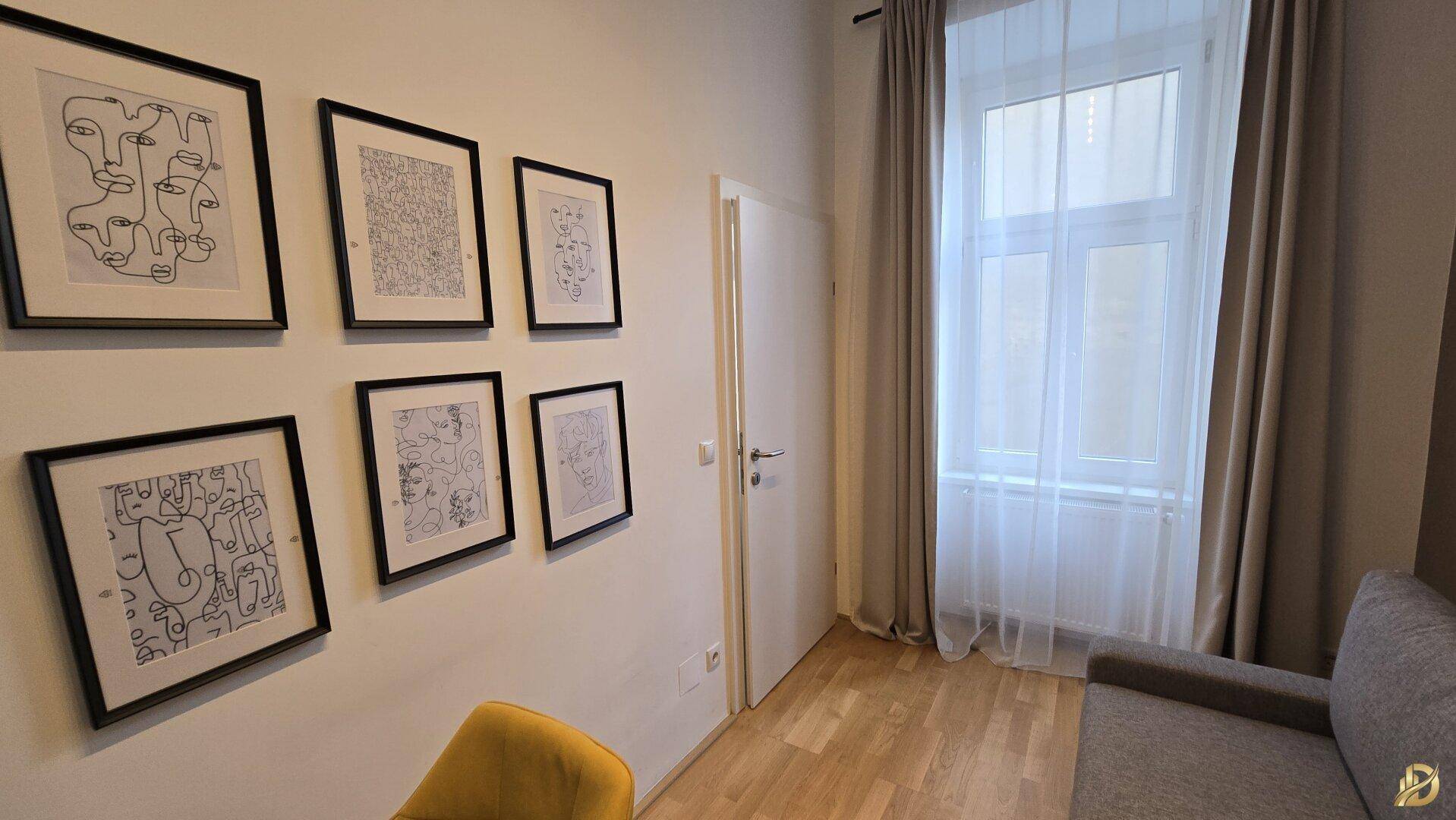 Kreativer Arbeitsplatz mit vielen Bildern, Holzboden und natürlichem Lichteinfall.