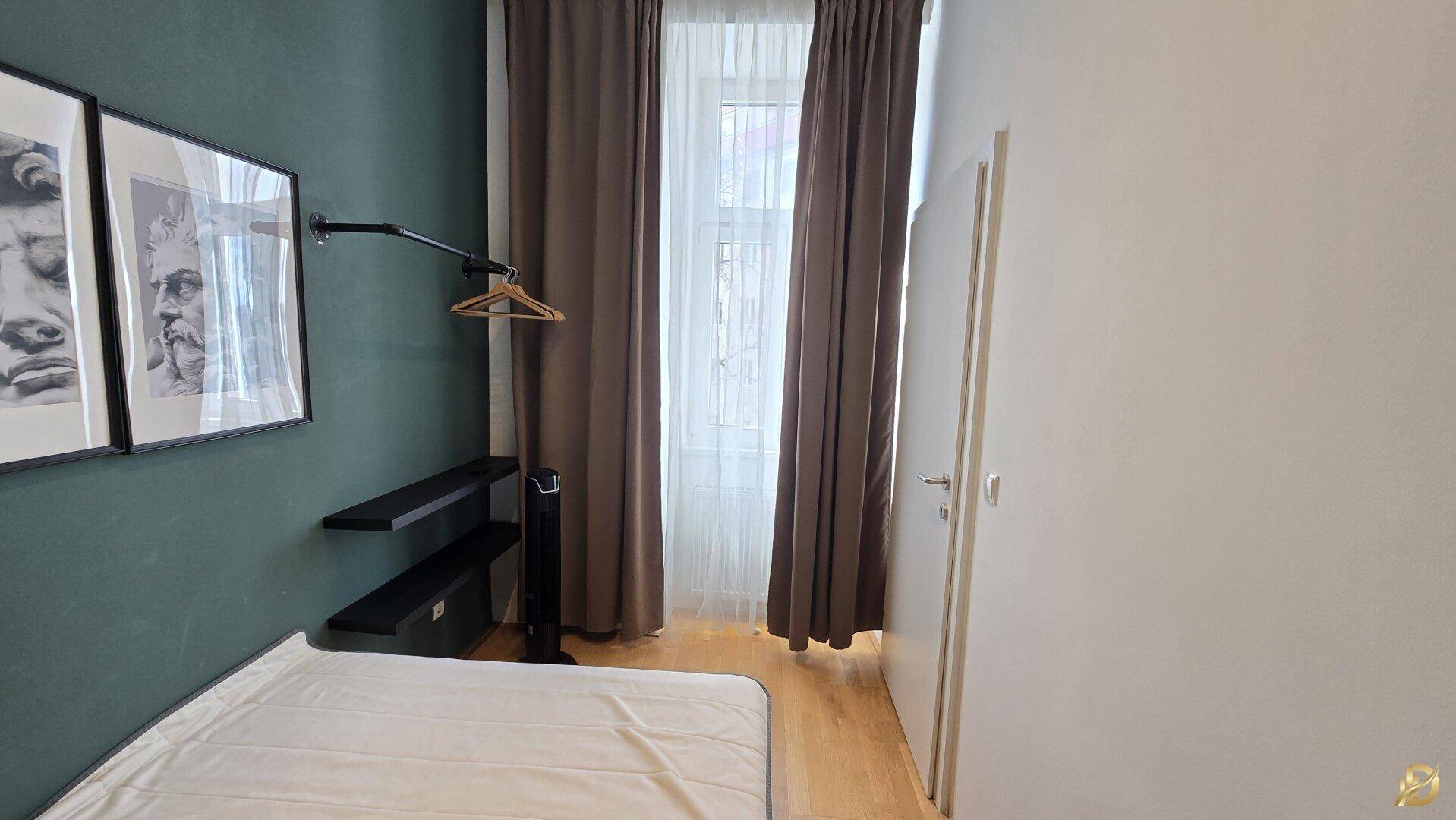 Helles Schlafzimmer mit Fenster, Vorhängen und minimalistischer Einrichtung für eine ruhige Atmosphäre.