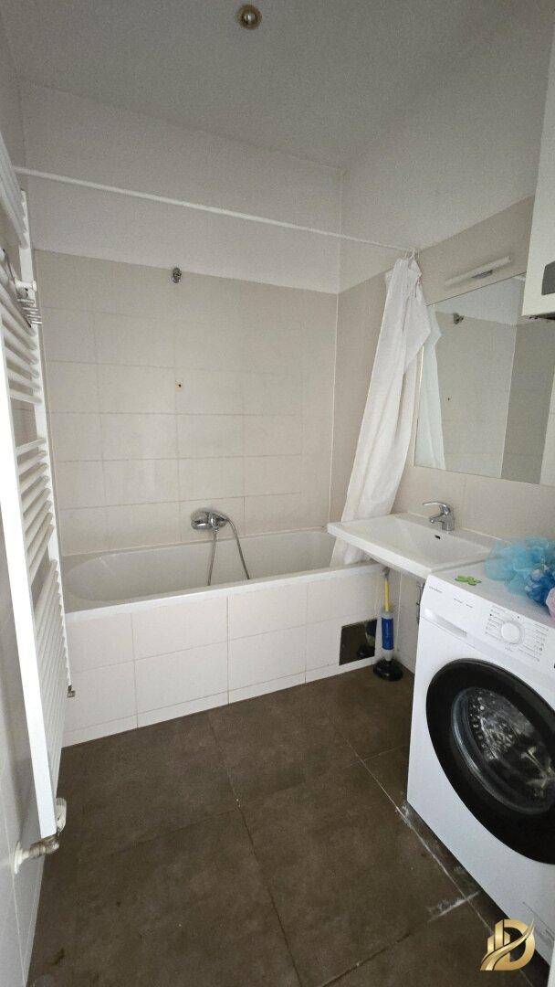 Badezimmer mit Badewanne, Waschbecken, Waschmaschine und beheiztem Handtuchhalter.