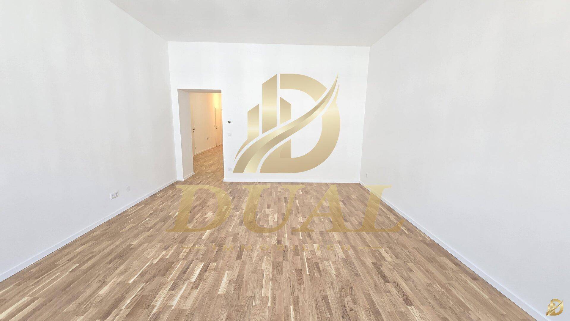 Leeres Zimmer mit Holzboden und Zugang zu einem weiteren Raum.