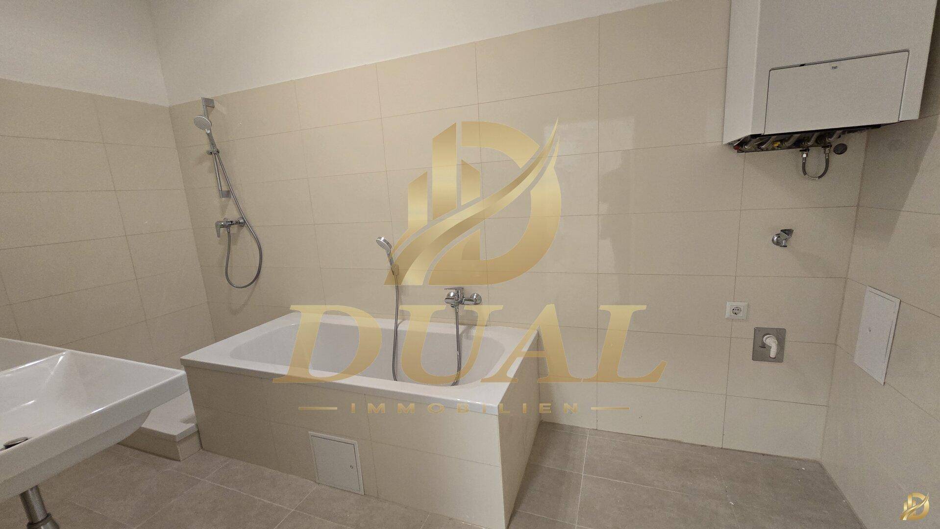Badezimmer mit eingebauter Badewanne und hellen Fliesen an Wänden und Boden.