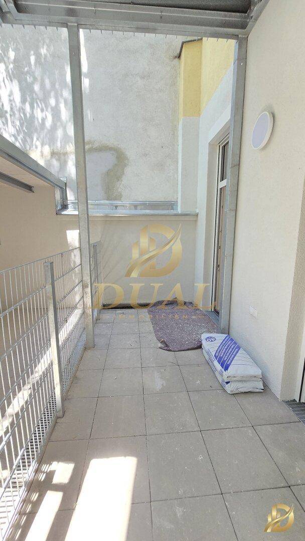 Geräumiger Balkon mit Fliesenboden und Überdachung, bietet Platz für Outdoor-Möbel.