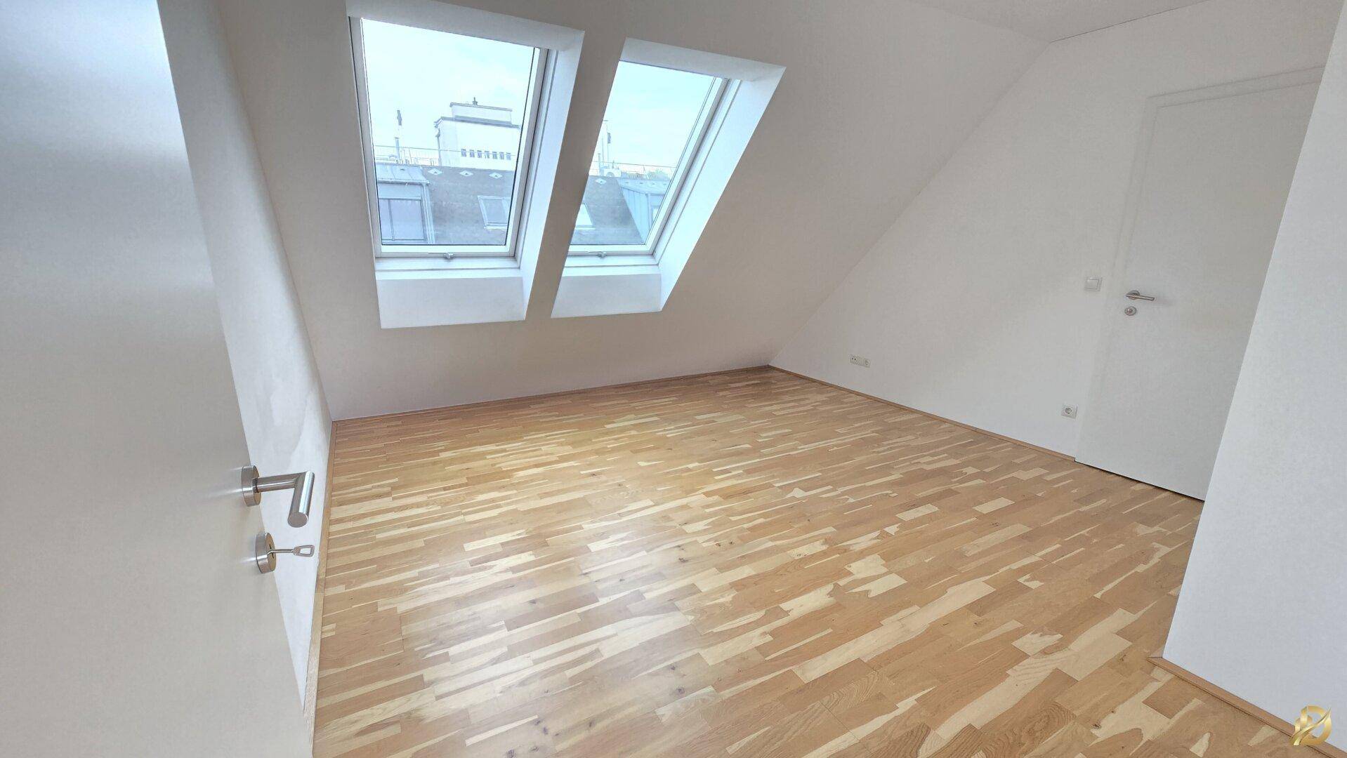 Schlafzimmer mit Holzboden und Dachfenstern, bietet viel natürliches Licht und Gemütlichkeit.