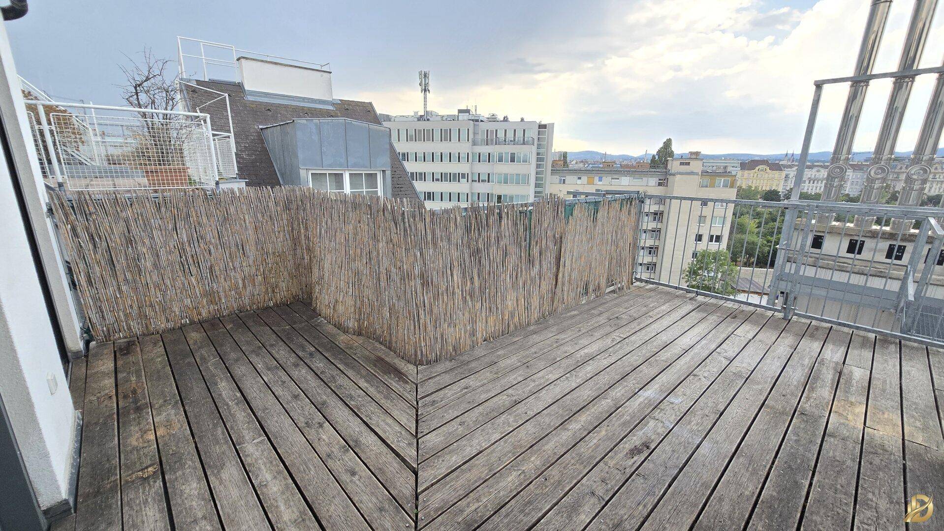 Große Dachterrasse mit Holzboden und weitem Blick über die umliegende Stadtlandschaft.
