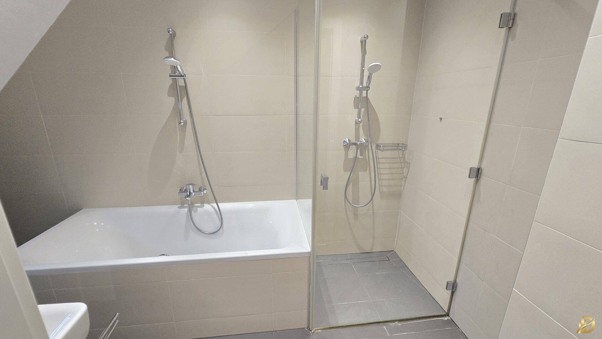 Modernes Badezimmer mit Badewanne und separater Duschkabine, hell gefliest und funktional.