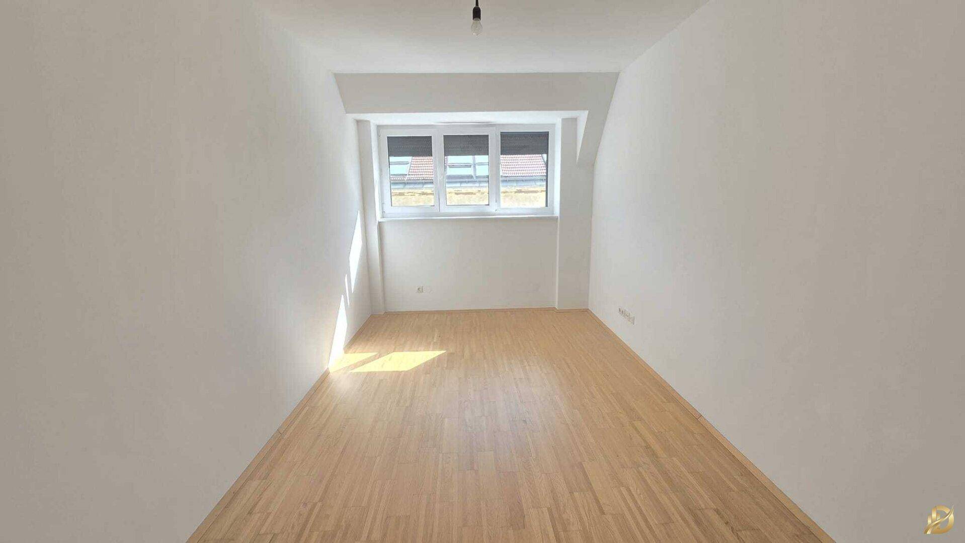 Geräumiges, helles Zimmer mit Holzboden und drei Fenstern für viel Tageslicht und eine offene Wirkung.