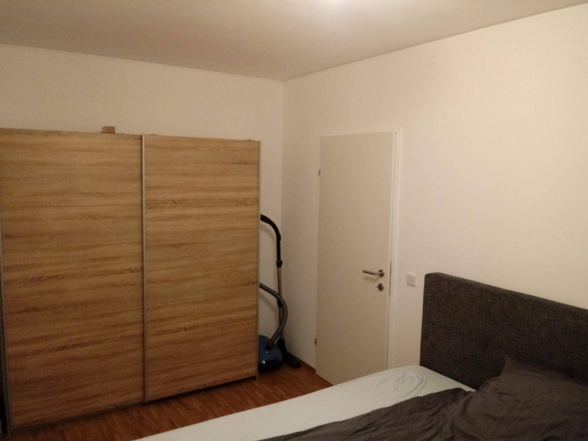 Geräumiges Schlafzimmer mit großem Kleiderschrank und Holzboden.
