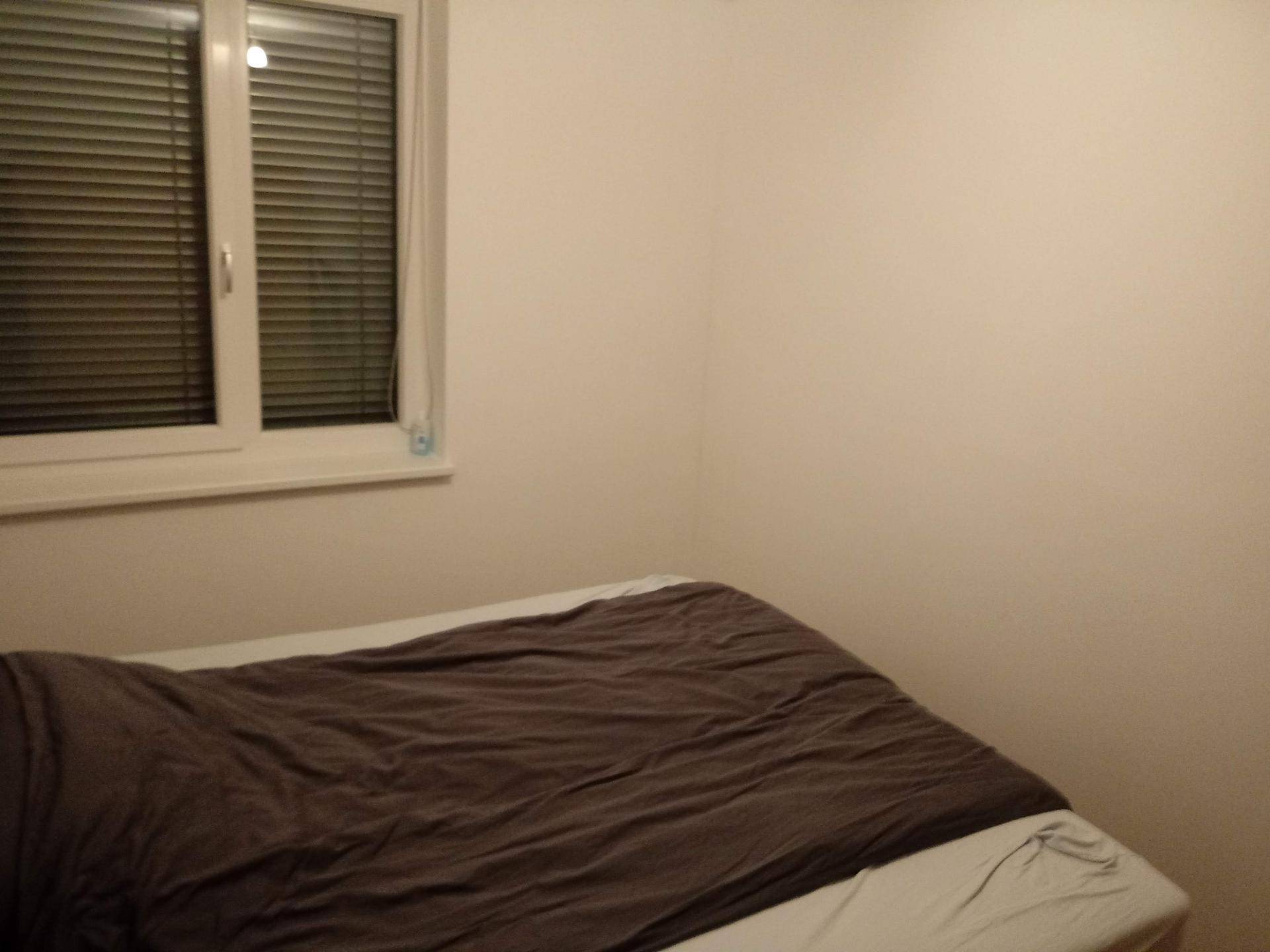 Schlafzimmer mit Bett und Fenster, das für Privatsphäre sorgt.