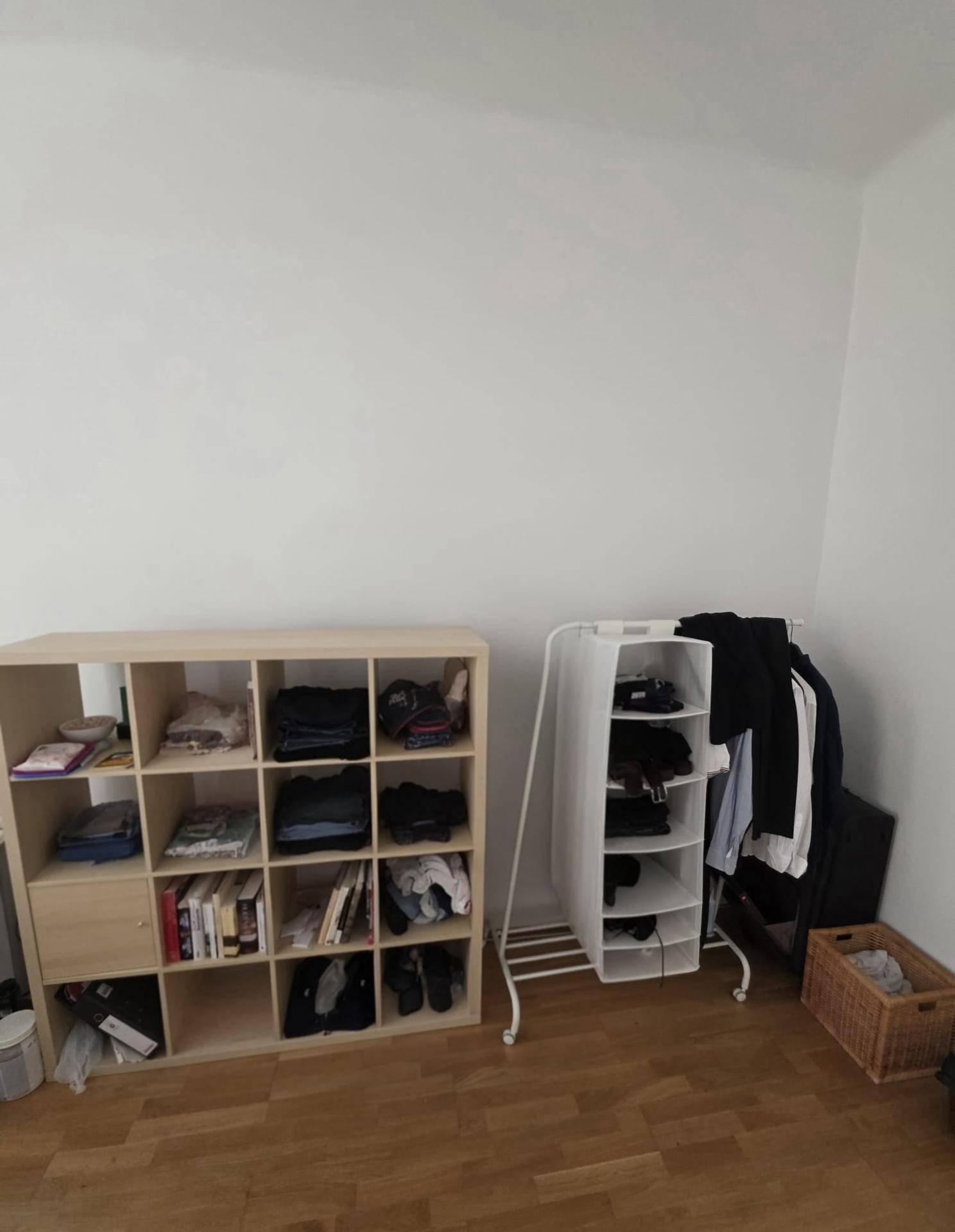 Lagerbereich mit Holzregal und Kleiderständer für zusätzlichen Stauraum.