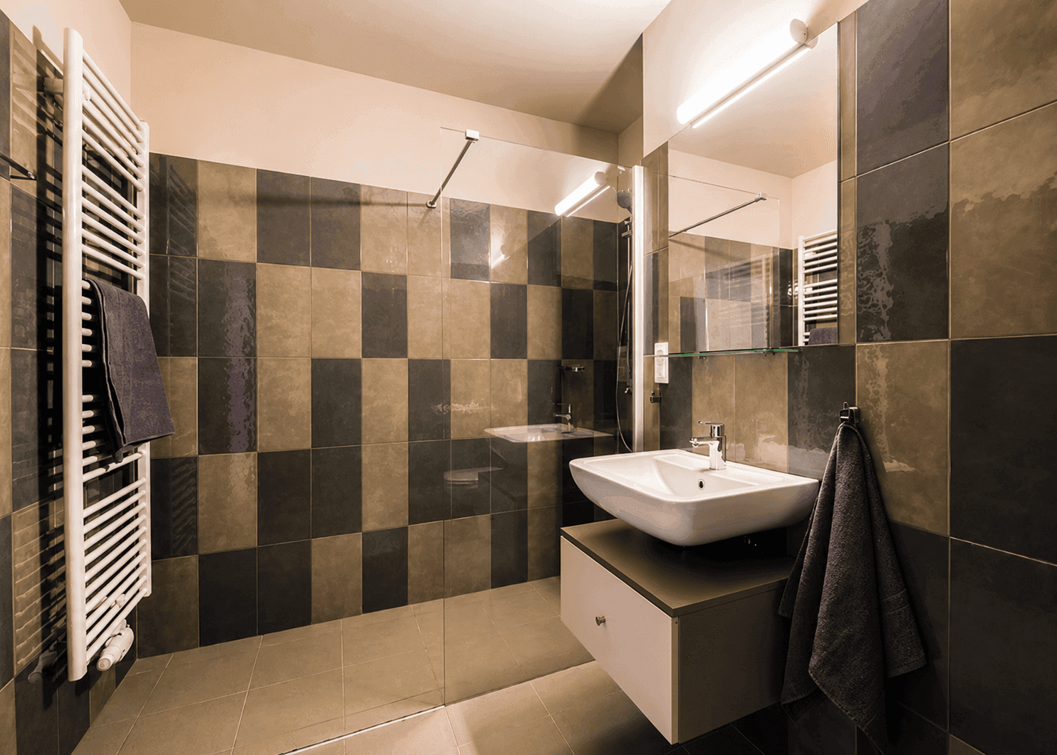 Modernes Badezimmer mit großformatigen Fliesen, Dusche und beheiztem Handtuchhalter.