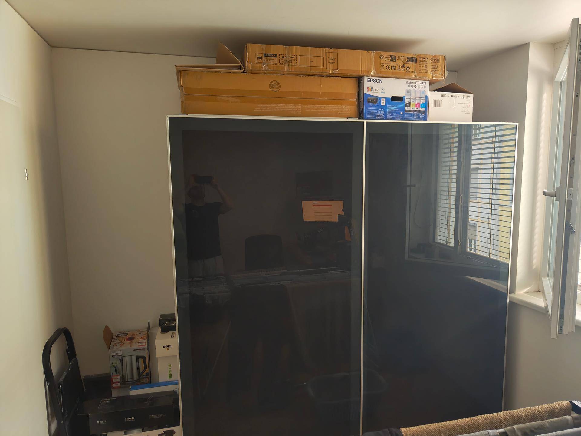 Raum mit einem großen Schrank und einem Fenster, das Tageslicht hereinlässt.