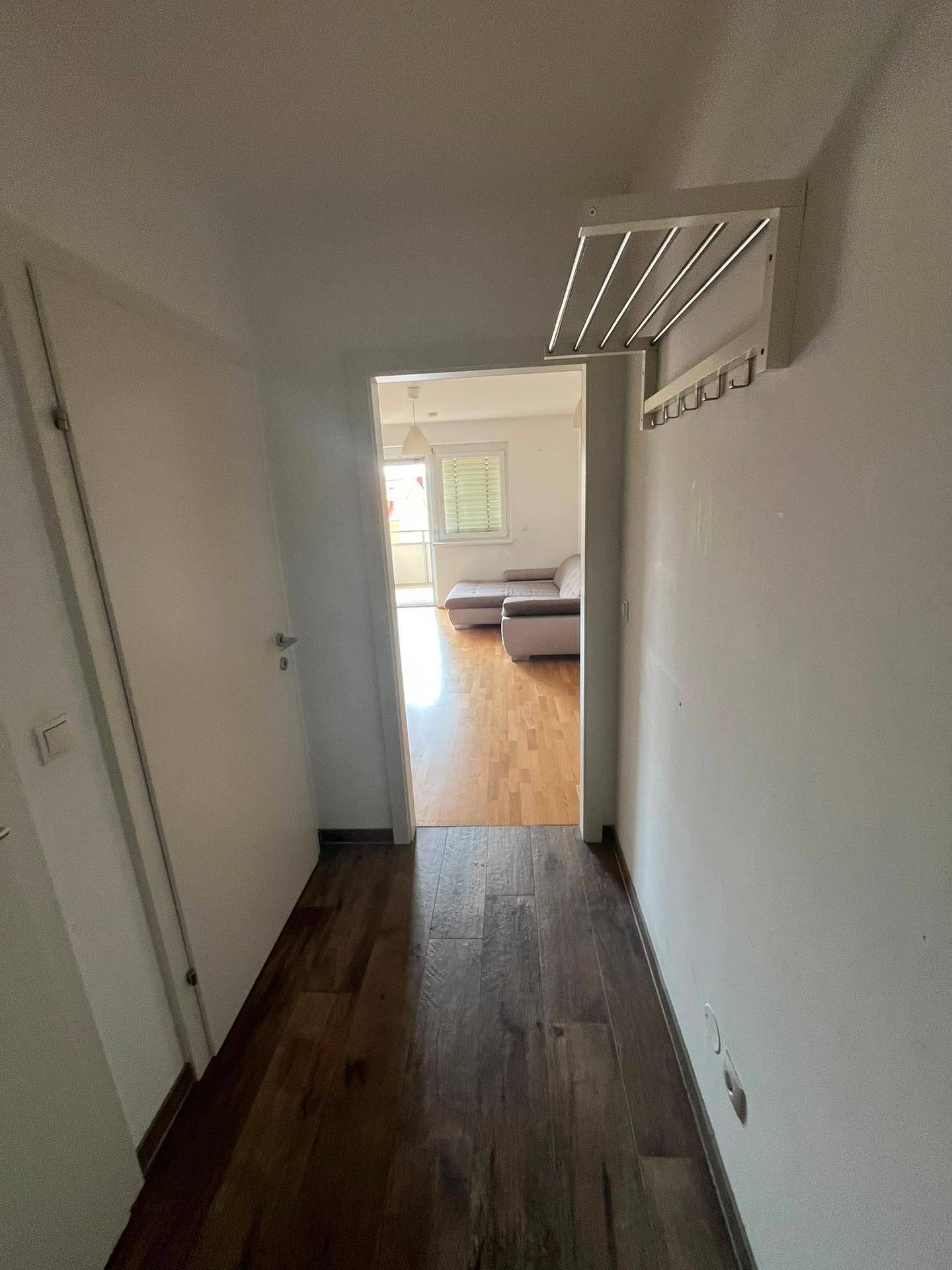 Heller Flur mit Garderobe und Fliesenboden, der in den Wohnbereich führt.