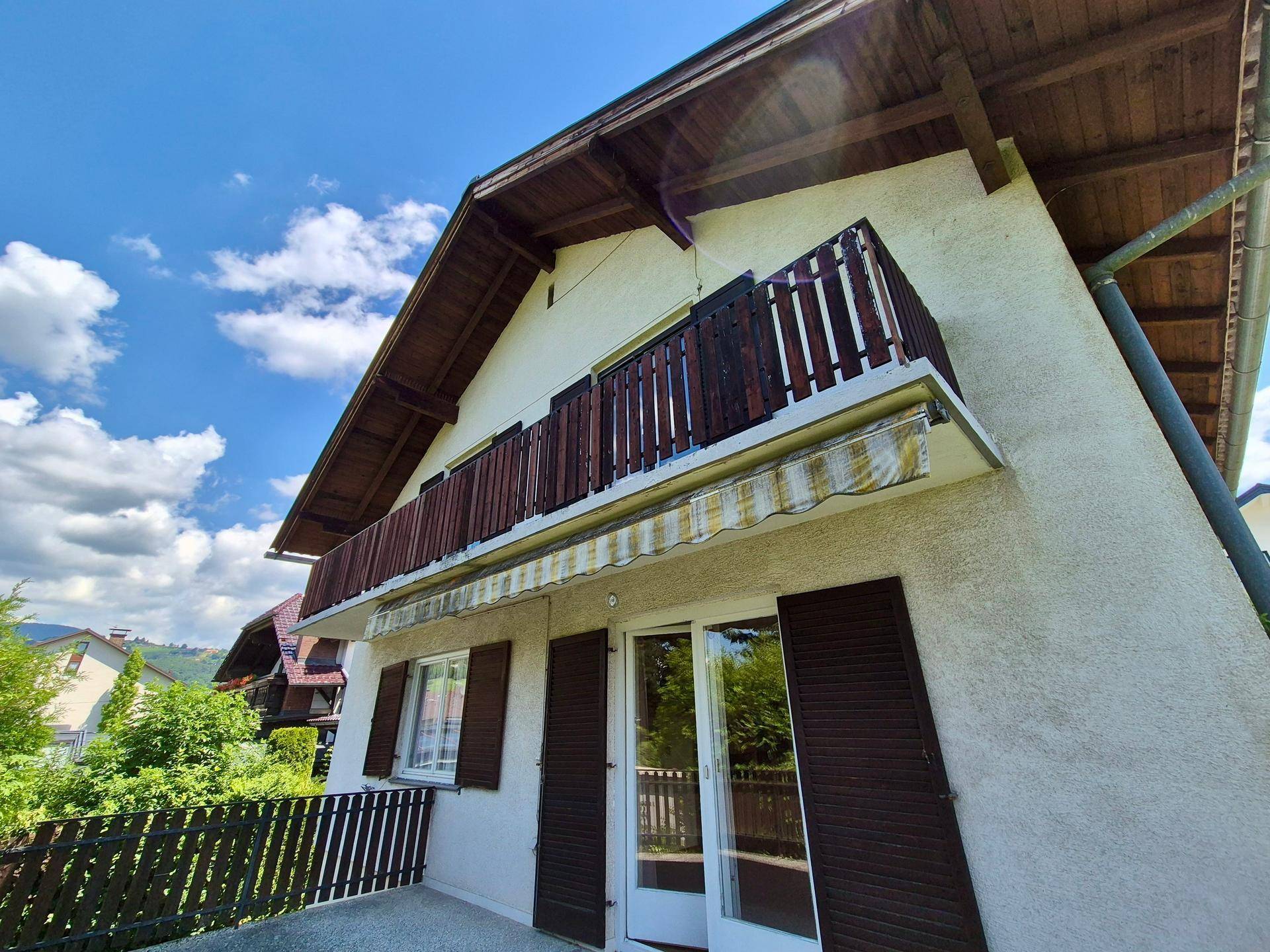 Fassade des Hauses mit einem Balkon, ausgestattet mit einer ausziehbaren Markise.
