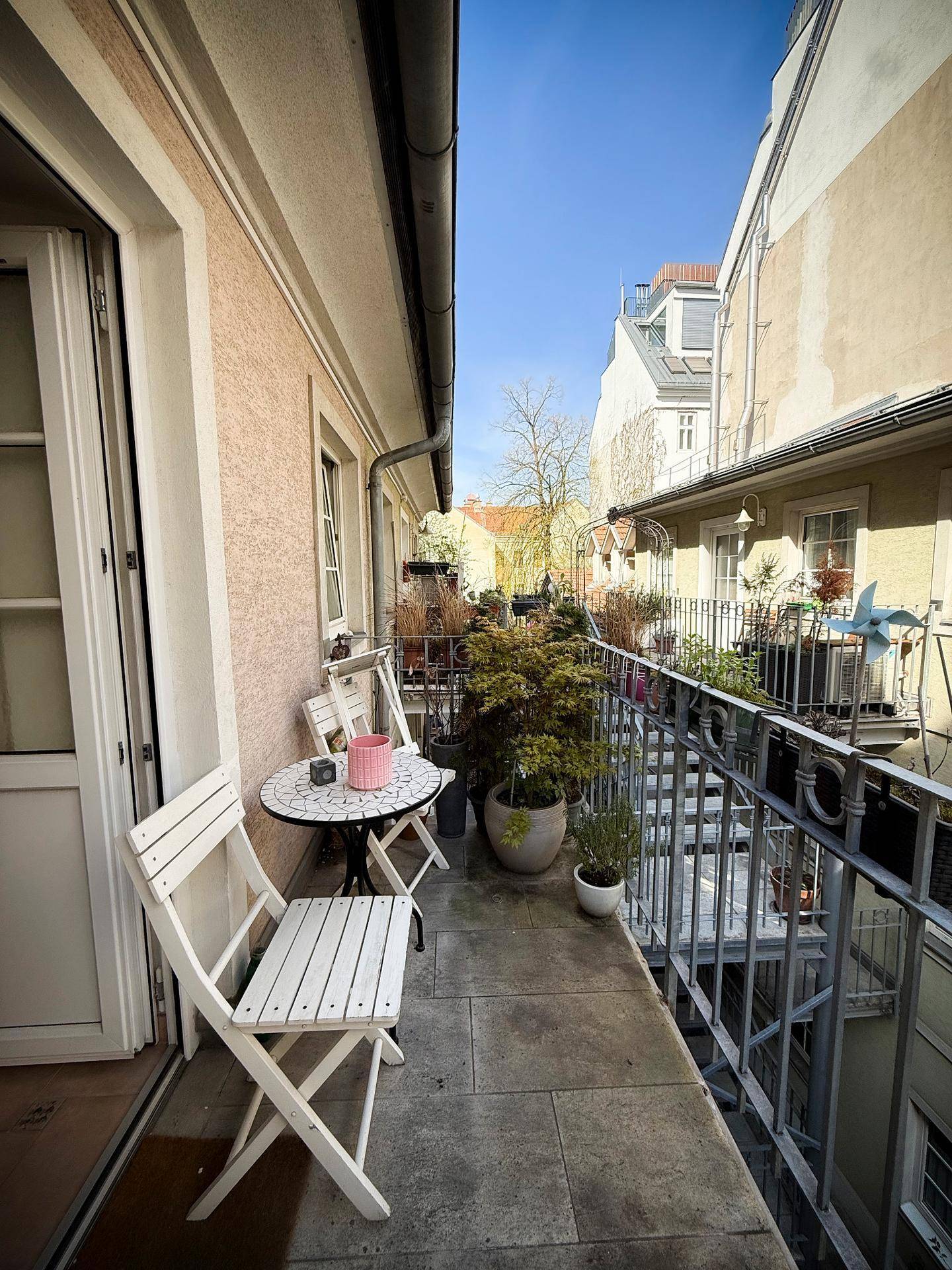 Gemütlicher kleiner Balkon mit Tisch und Stühlen, ideal für entspannte Stunden im Freien.