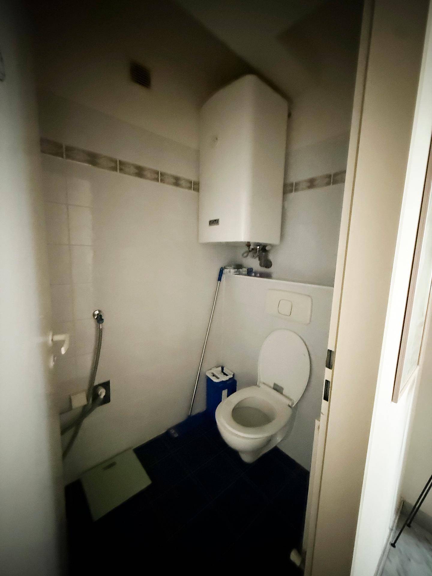 Separates WC mit Toilette und Wandboiler, funktional und platzsparend gestaltet.