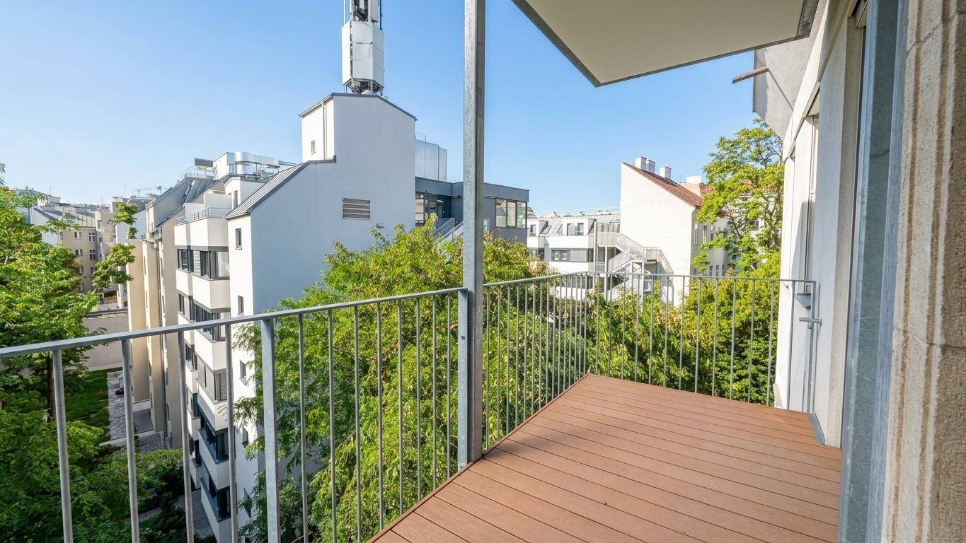 Balkon mit Holzboden und Metallgeländer bietet einen grünen Blick auf die umliegenden Gebäude.