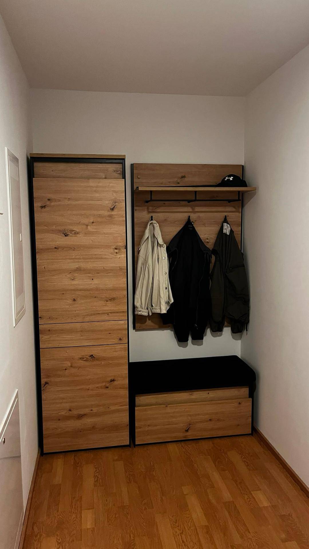 Moderner Flur mit Holzgarderobe, integrierter Sitzbank und praktischem Stauraum für Kleidung und Schuhe.