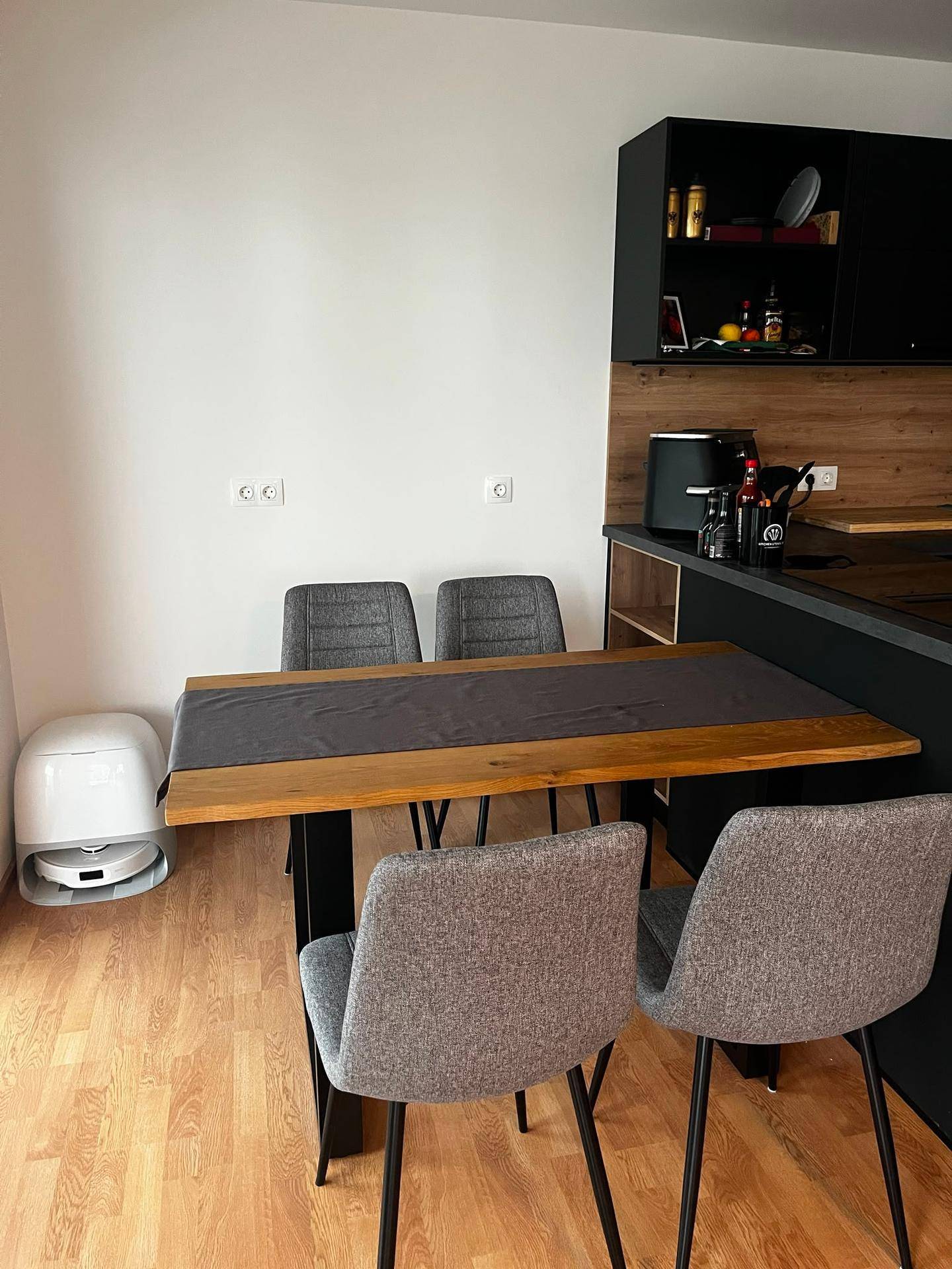 Essbereich mit Holztisch und modernen Stühlen, direkt angrenzend an die Küche, ideal für Mahlzeiten.