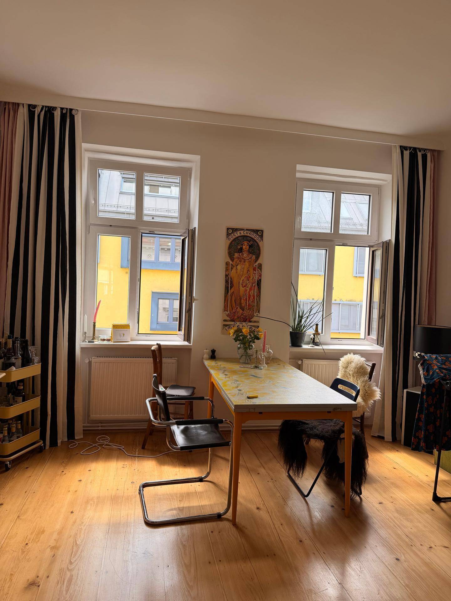 Heller Essbereich mit Holzboden, Esstisch und Fenstern mit Blick auf die Umgebung.