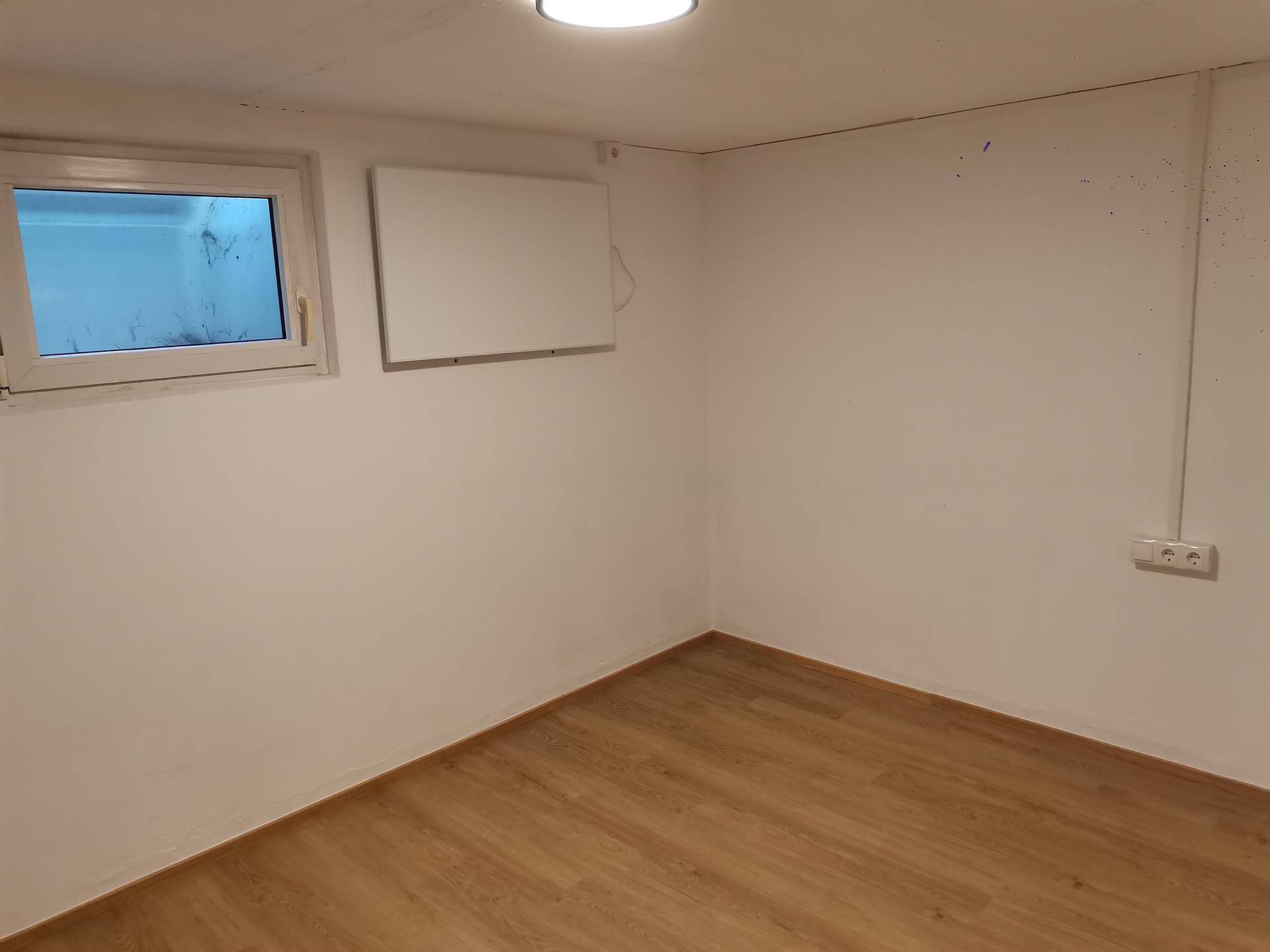 Heller Kellerraum mit Laminatboden und kleinem Fenster, ideal als Abstell- oder Hobbyraum.
