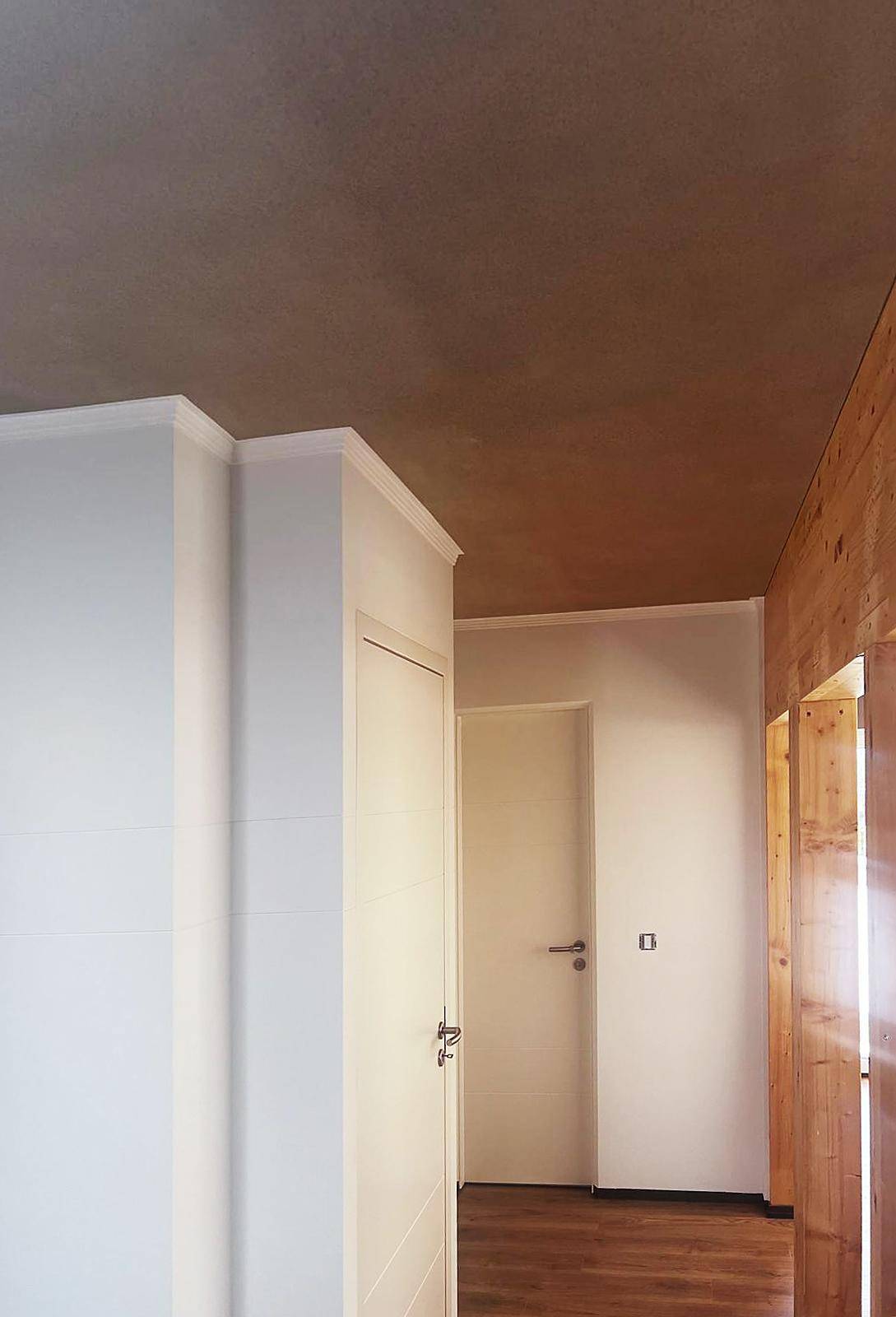 Flur mit mehreren Türen, Holzboden und schlichter Deckenleiste.