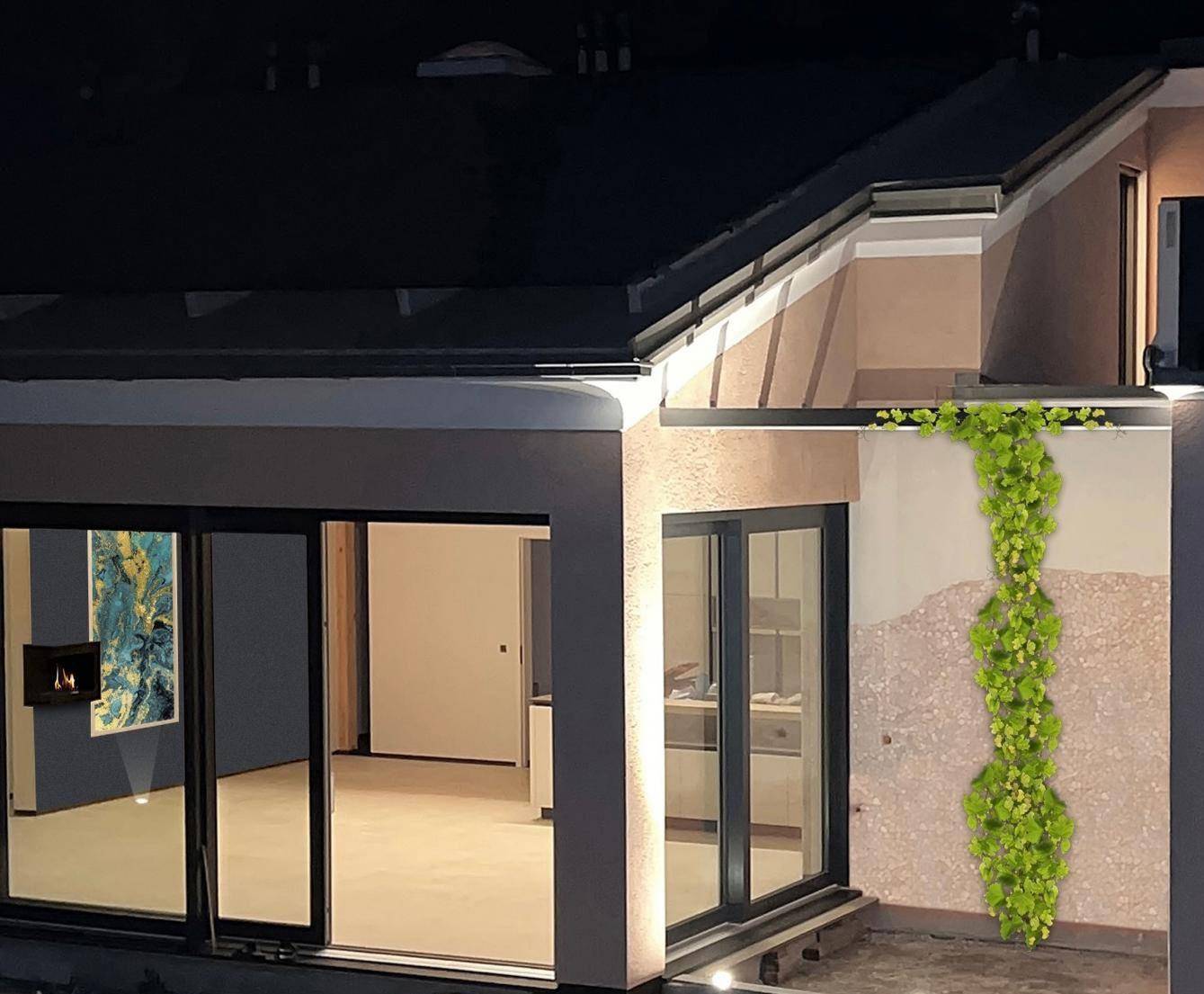 Innenansicht eines Wohnzimmers mit Kamin und grüner Wanddekoration, von außen betrachtet.