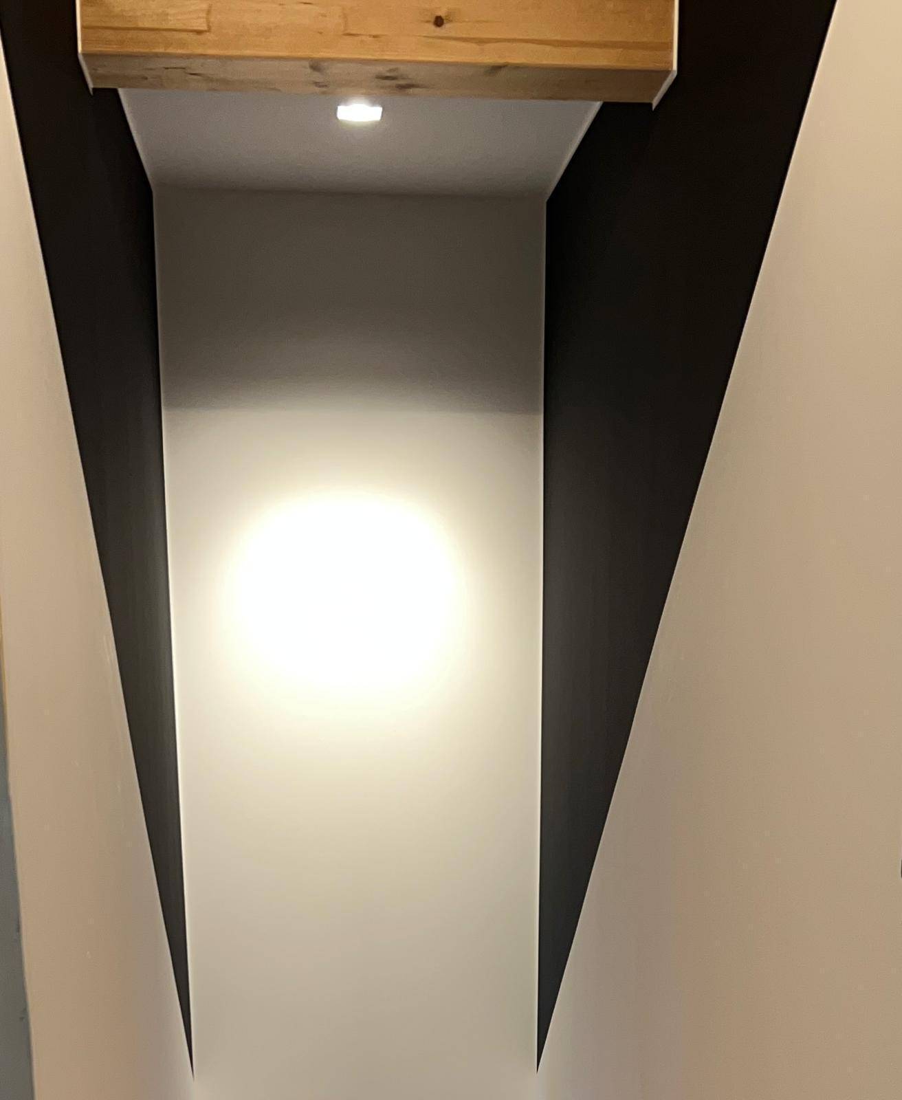 Blick nach oben in einen hell beleuchteten Treppenbereich mit minimalistischem Design.