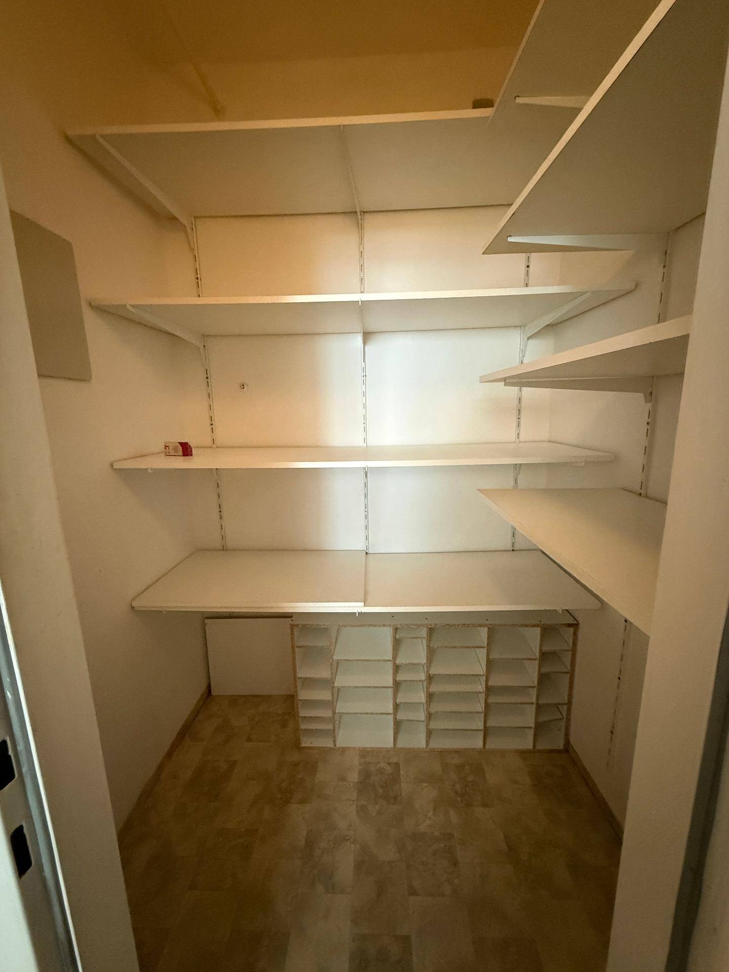 Praktischer Abstellraum mit vielen Regalen für zusätzlichen Stauraum und Organisation.