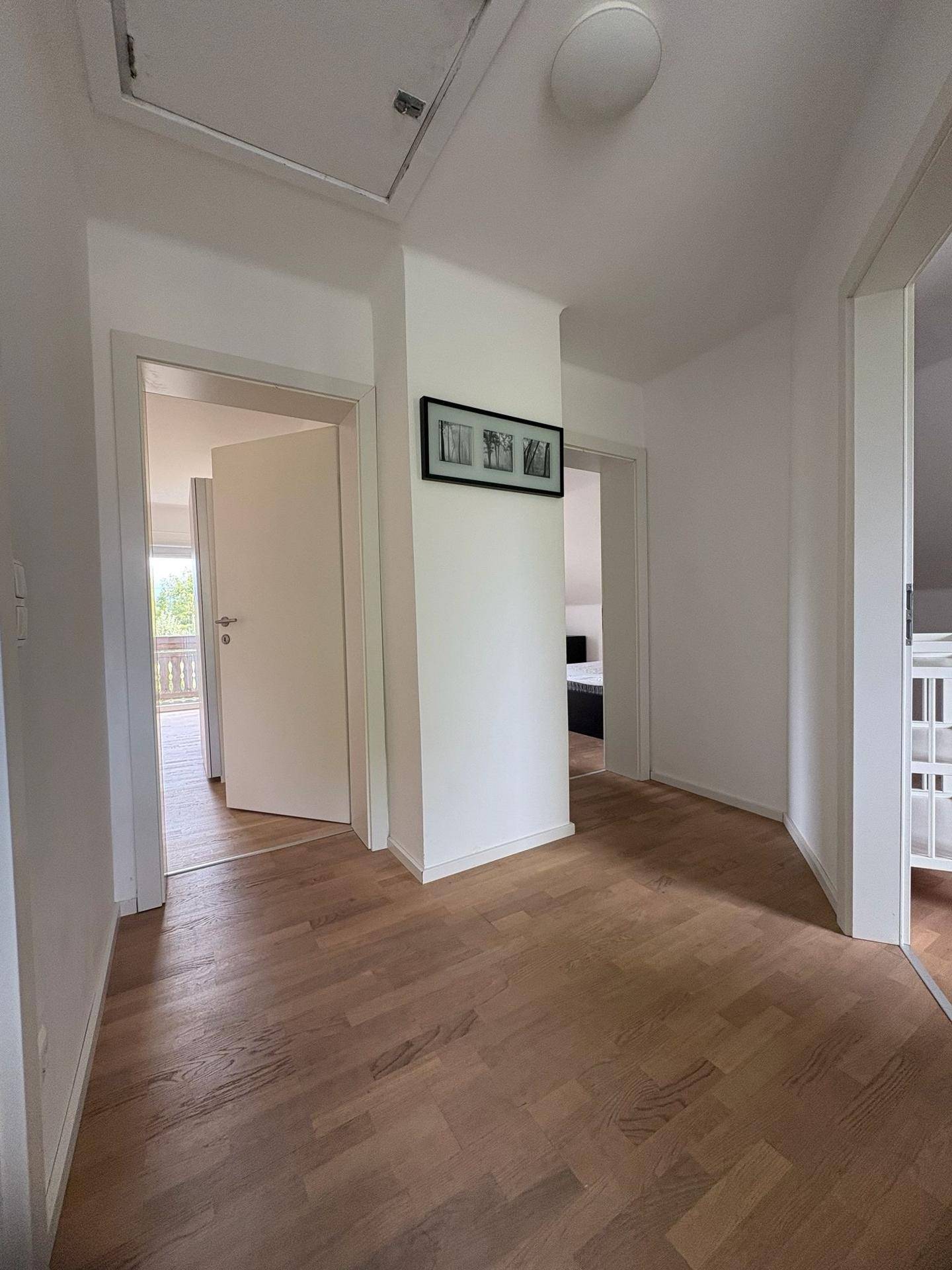 Heller Flur mit Holzboden und Türen zu verschiedenen Räumen, die eine offene Atmosphäre schaffen.