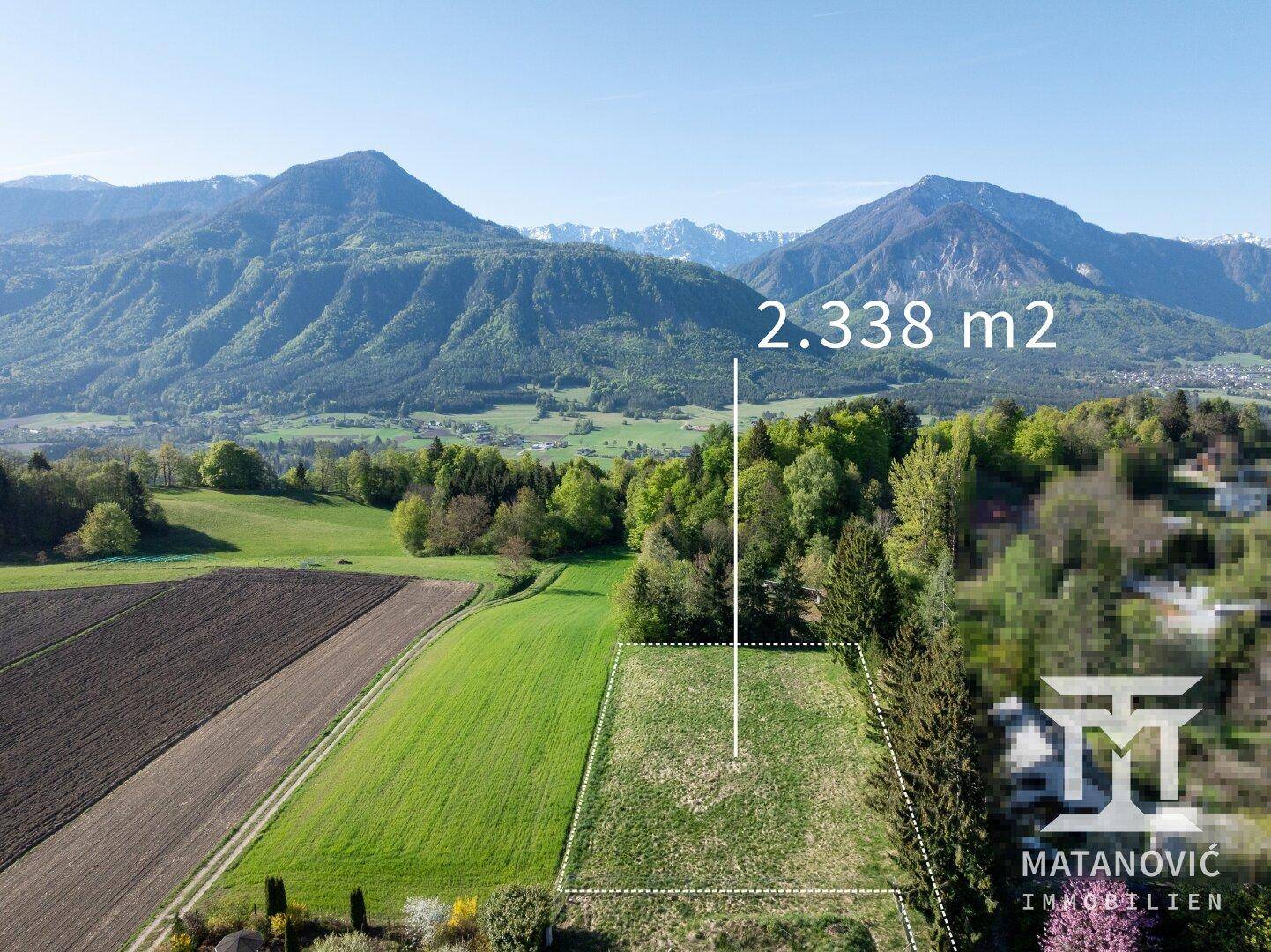 Luftaufnahme eines Grundstücks mit 2.338 m² Fläche und malerischem Bergblick in der Ferne.