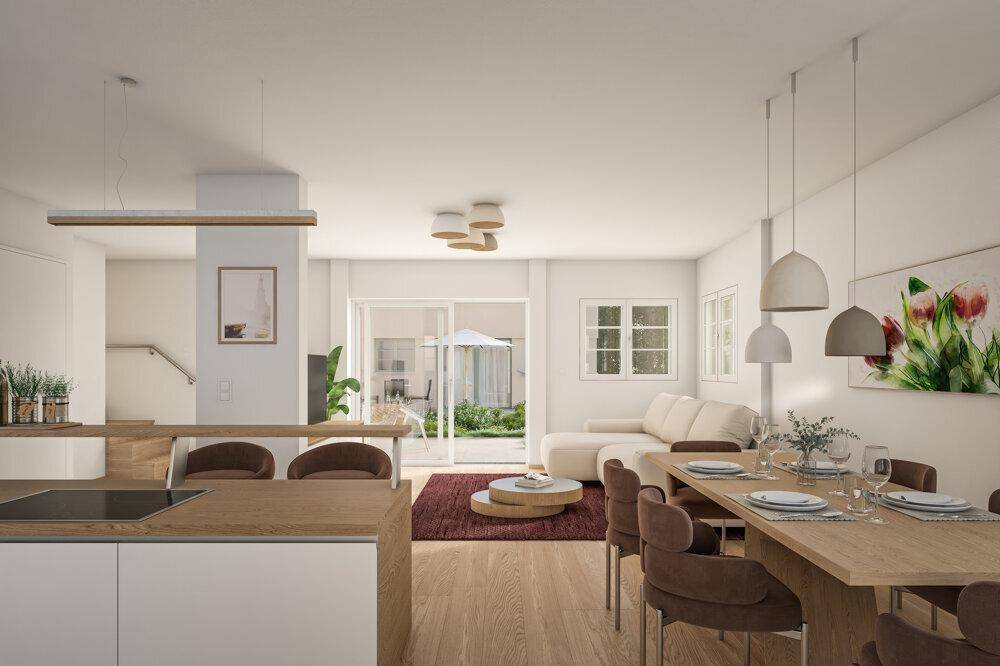 Heller offener Wohn-Essbereich mit moderner Küche, Holzboden und Zugang zur Terrasse.