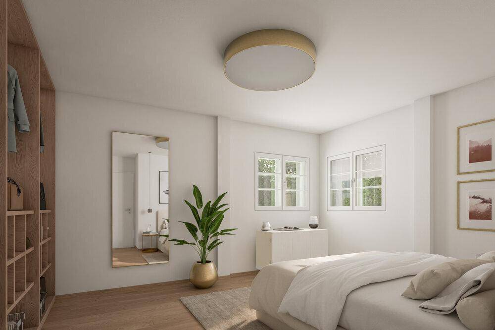 Helles Schlafzimmer mit Holzboden, großem Spiegel und integriertem Kleiderschrank.