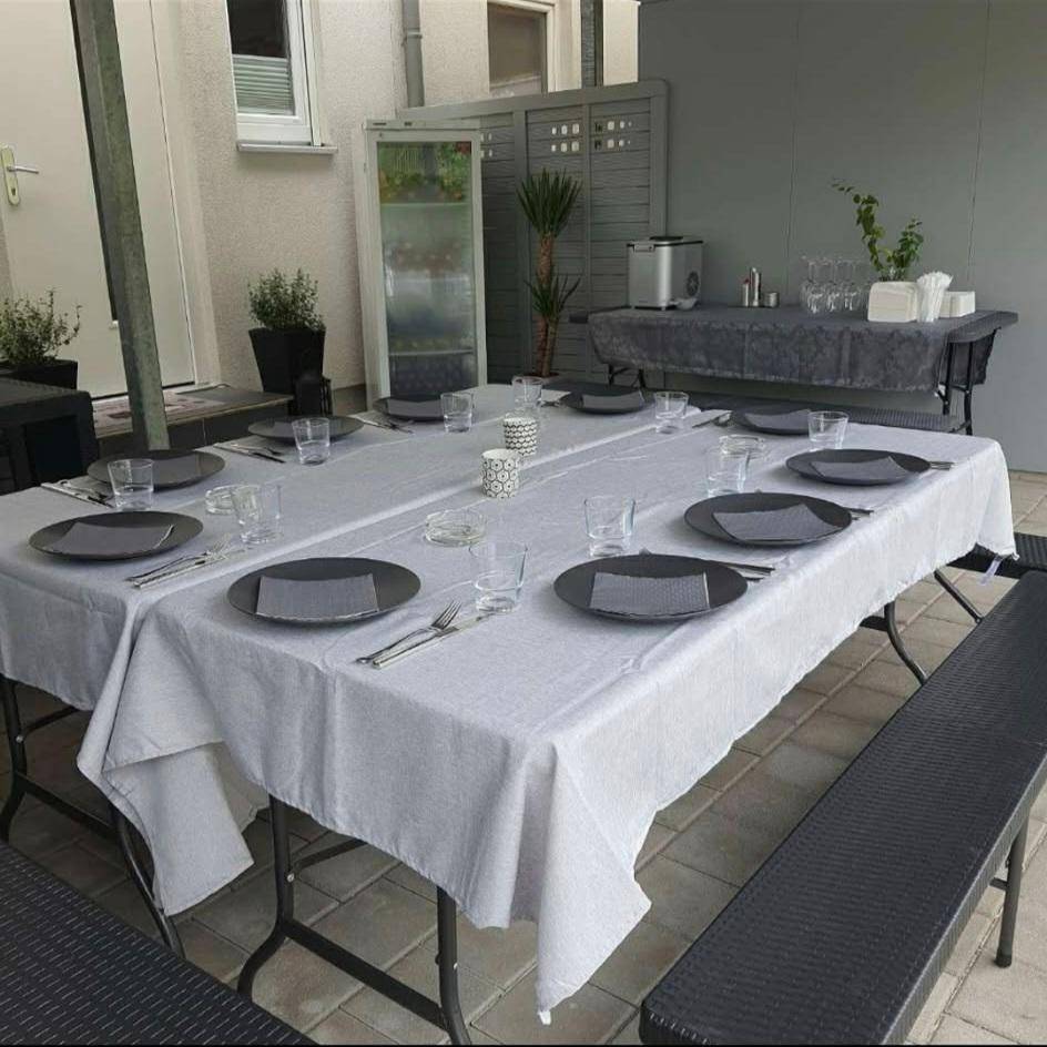Gedeckter Essbereich im Freien mit großem Tisch und Bänken für gesellige Runden und Feiern.