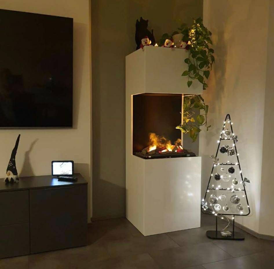 Gemütlicher Wohnbereich mit modernem Elektrokamin, Fernseher und festlicher Dekoration.