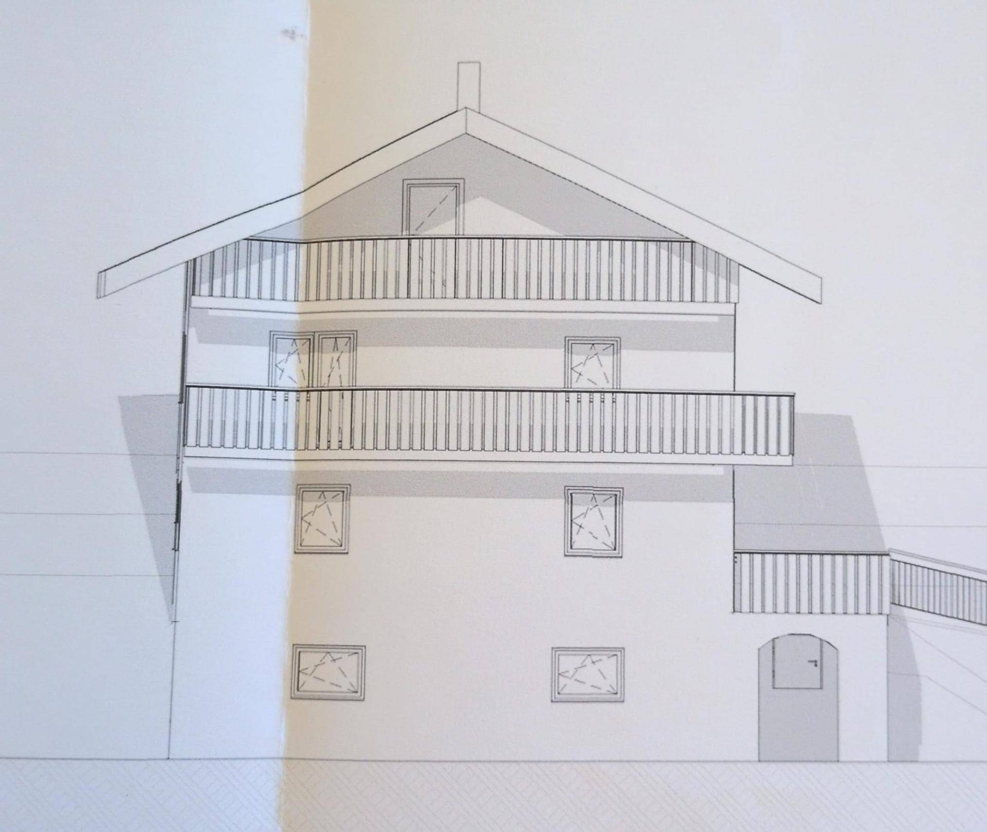 Seitenansicht des Hauses mit traditionellen Balkonen und Giebeldach.