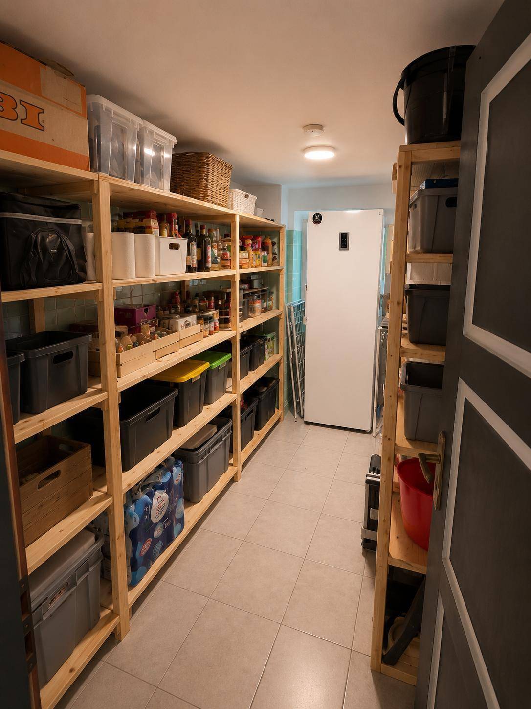 Geräumige Speisekammer mit vielen Regalen und einem Kühlschrank für Vorräte.